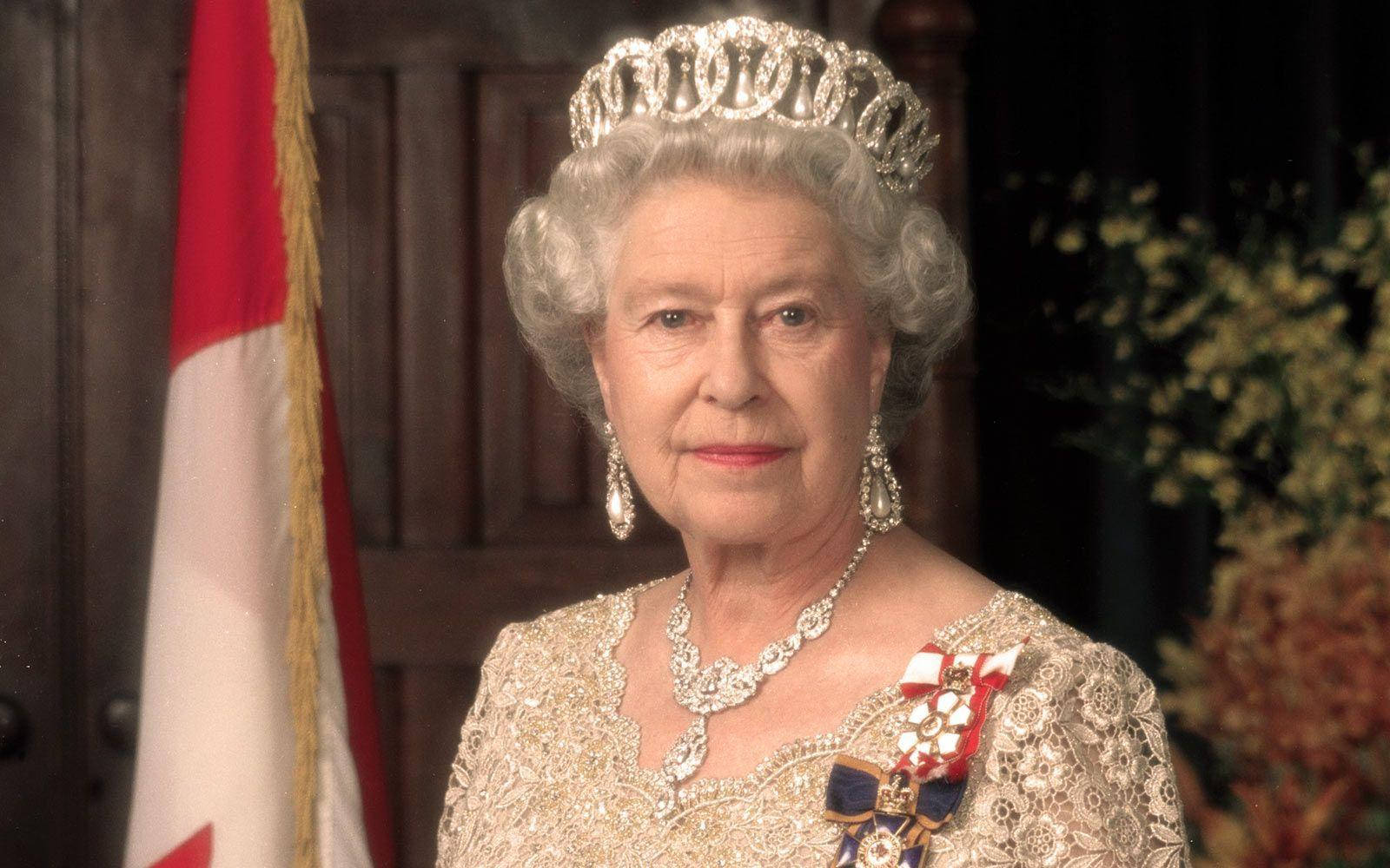 Queen Elizabeth 桌布 壁紙 — 伊莉莎白二世女王身穿華麗服飾，佩戴閃爍的頭飾項鍊和耳環，站在加拿大國旗前，拍攝正式肖像。