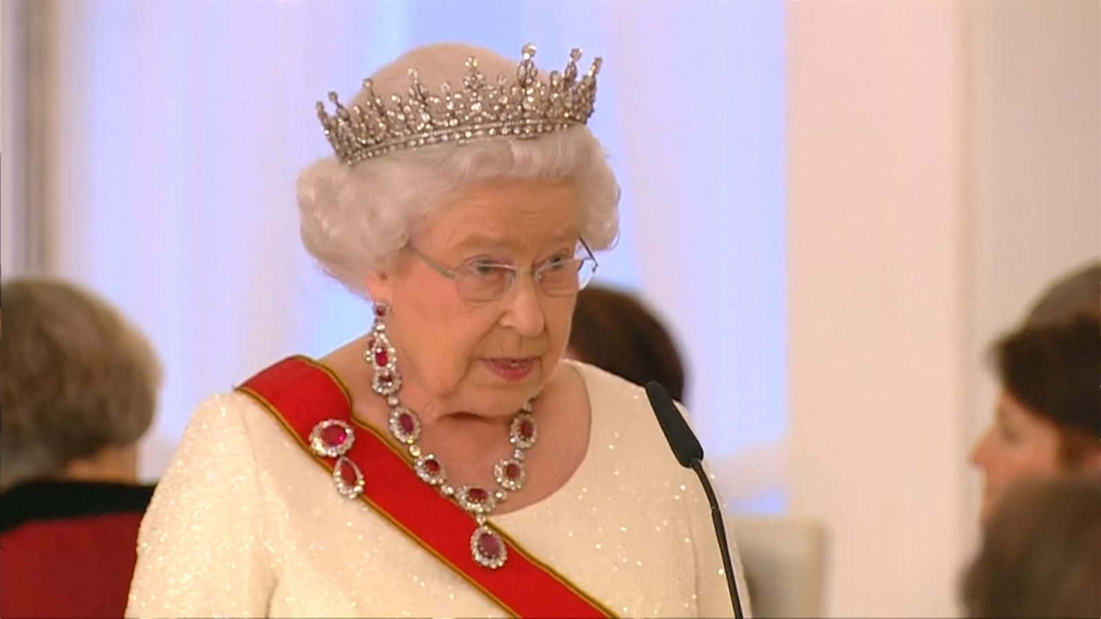 Queen Elizabeth 桌布 壁紙 — 伊麗莎白二世女王佩戴閃爍的頭飾和紅寶石飾帶，在室內的正式活動中發言。
