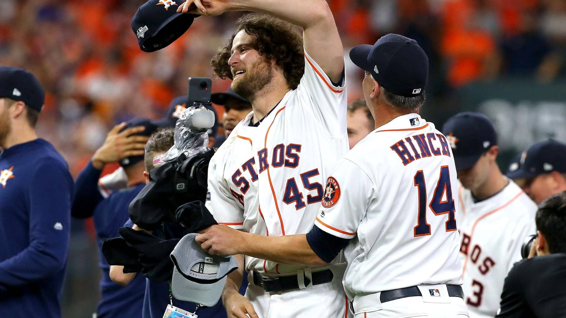 Gerrit Cole 桌布 壁紙 — 休士頓太空人45號球員在慶祝時舉起帽子，隊友Hinch在棒球場上擁抱他。