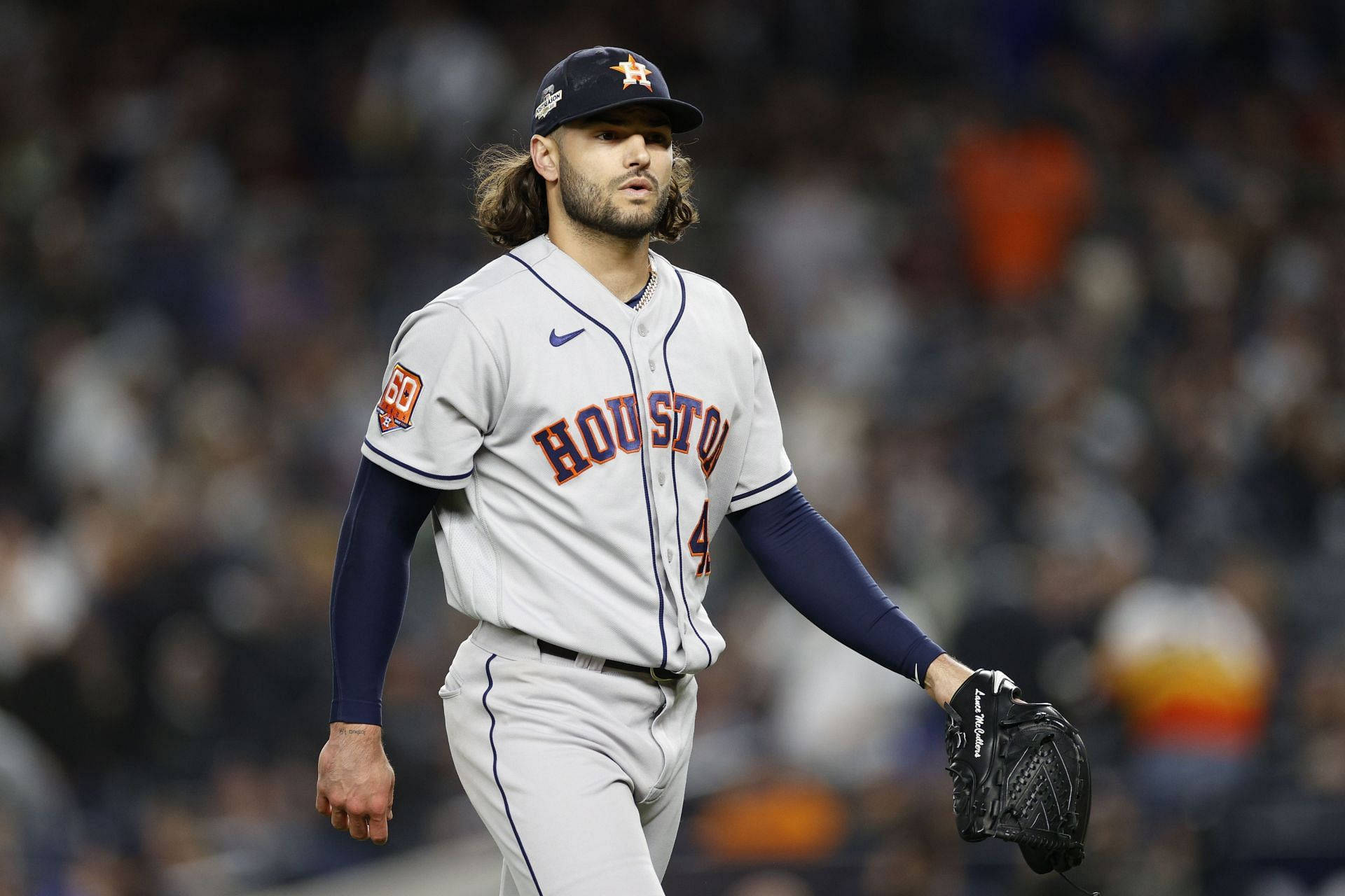 Houston Astros 桌布 壁紙 — 休士頓太空人投手在夜間比賽中，在球場燈光下離開投手丘，背景有模糊的球迷。