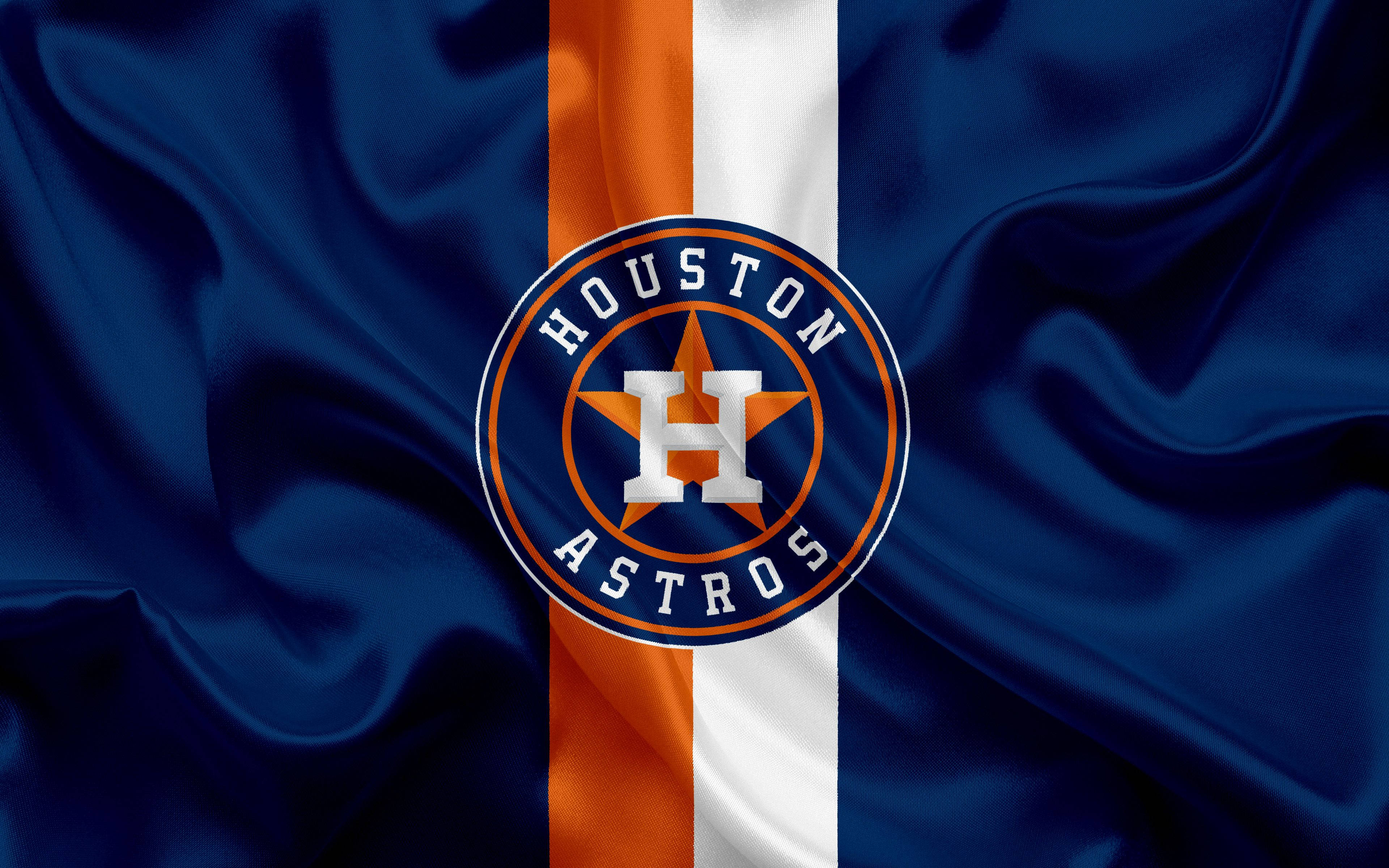 Astros 桌布 壁紙 — 休士頓太空人隊標誌置中於帶有緞面皺褶的飄揚藍橙白旗幟上。