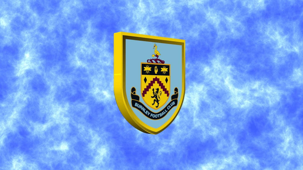 Burnley Fc 桌布 壁紙 — 伯恩利足球俱樂部隊徽在充滿活力的藍色多雲天空中飄浮，帶有金色邊框和詳細的紋章符號。