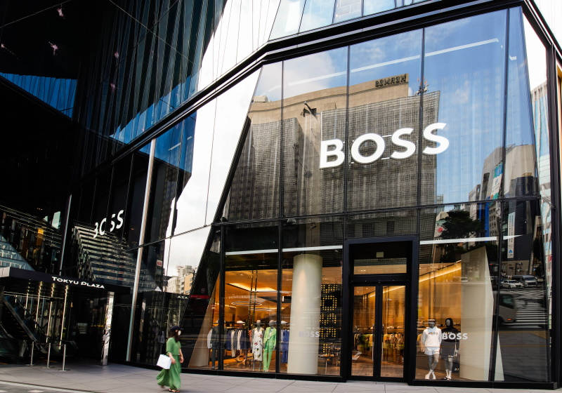 Building 桌布 壁紙 — 位於現代東京廣場的時尚BOSS商店，配備反光玻璃外牆和發光的室內燈光。