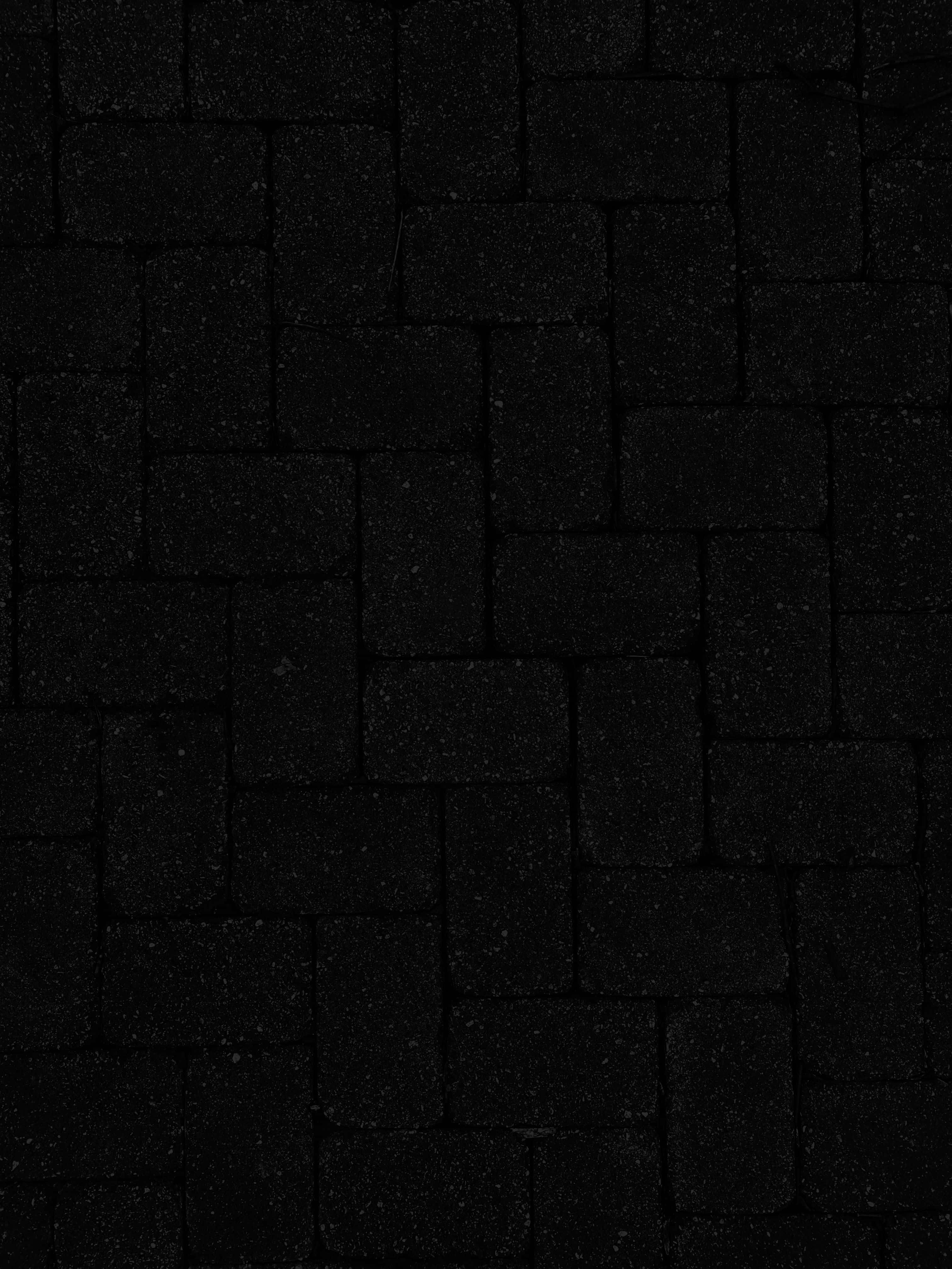 Dark Textured 桌布 壁紙 — 低光下帶有細微斑點和不規則磚紋的深色紋理石鋪路。