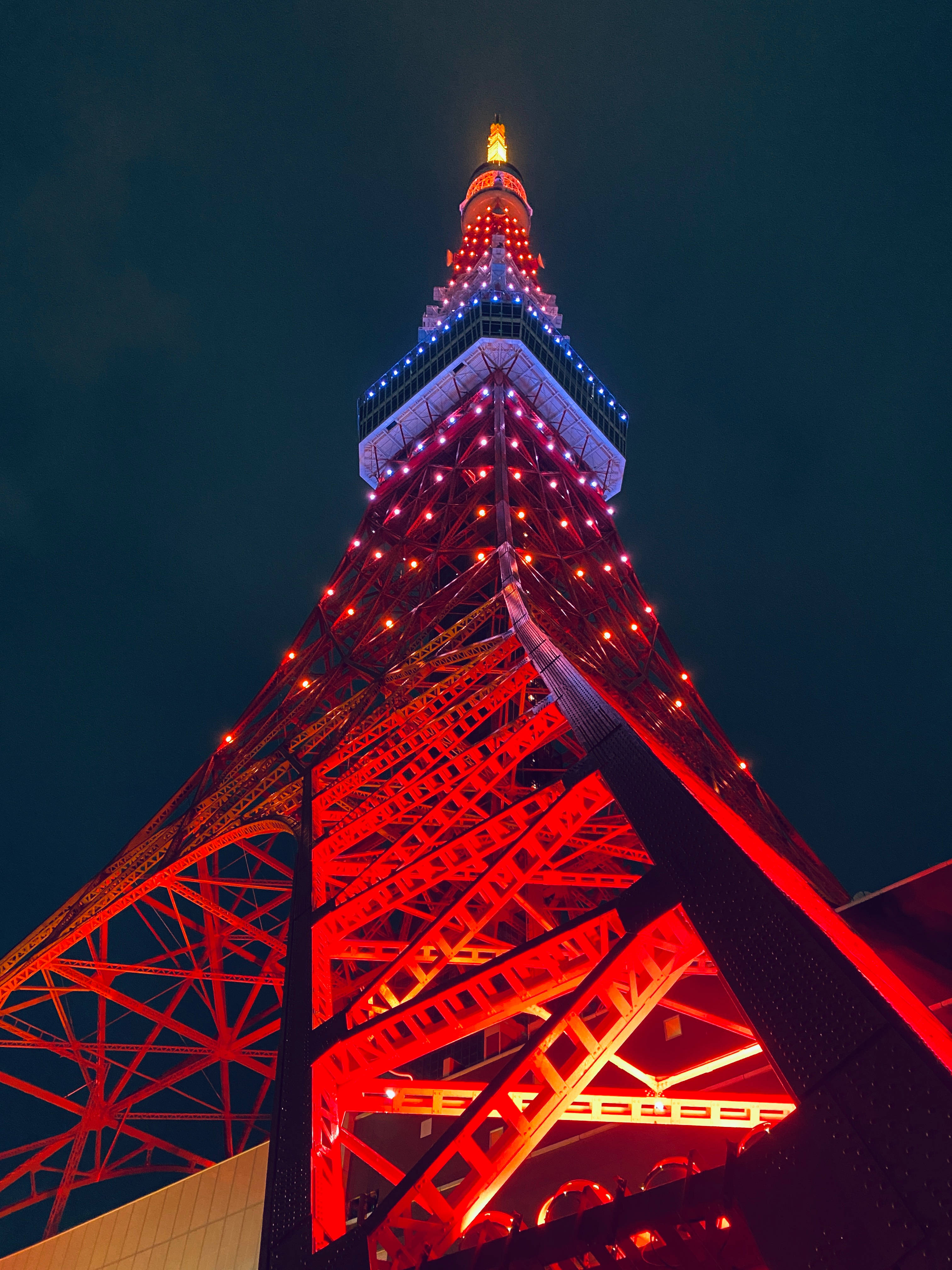 日本 桌布 壁紙 — 低角度夜攝東京鐵塔，在黑暗天空中散發出鮮豔的紅光。