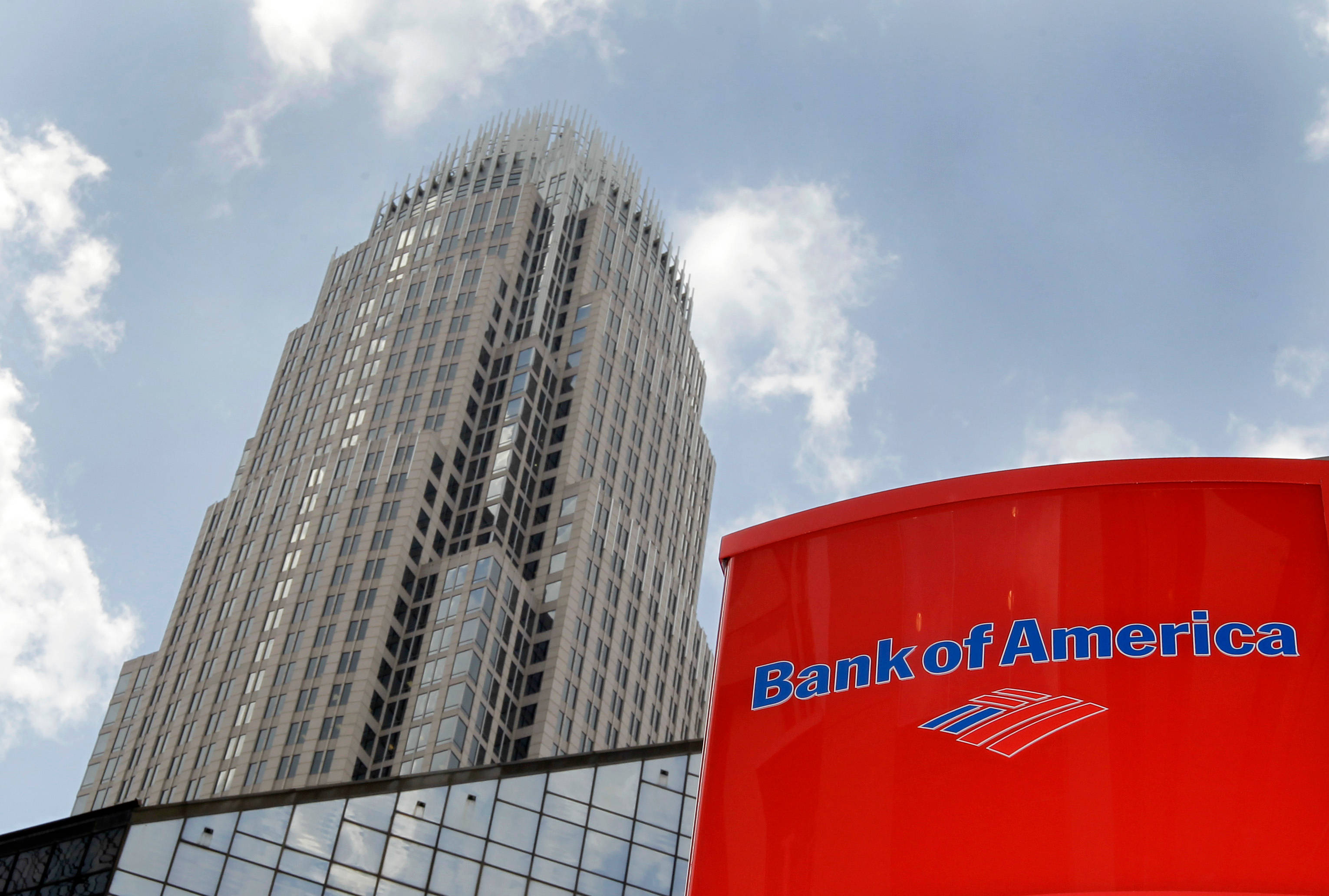 Bank 桌布 壁紙 — 低角度拍攝一座現代玻璃摩天大樓，聳立於紅色美國銀行分行之上，背景是局部多雲的藍天。