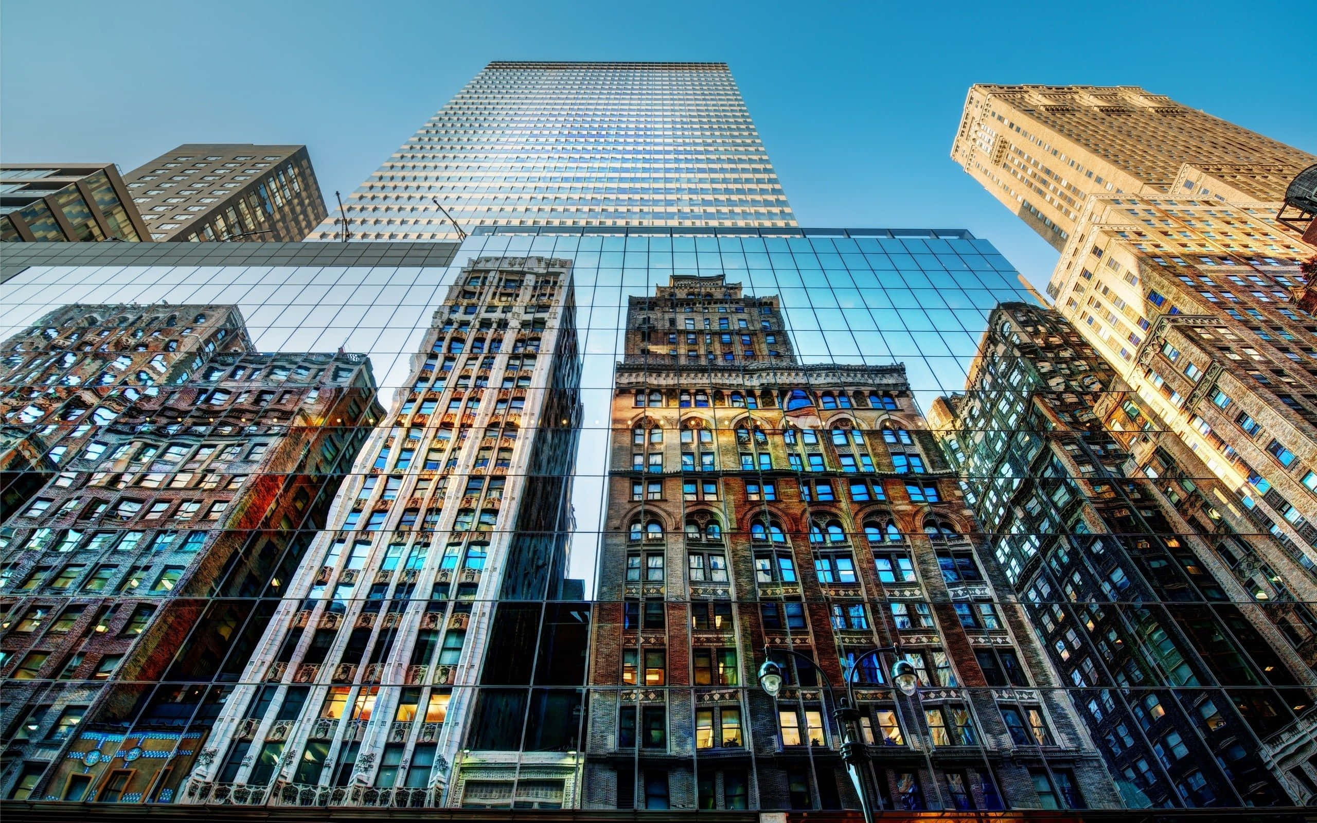 Buildings 桌布 壁紙 — 低角度拍攝捕捉到高聳的玻璃摩天大樓，在清澈的藍天下反射著歷史悠久的磚造建築。