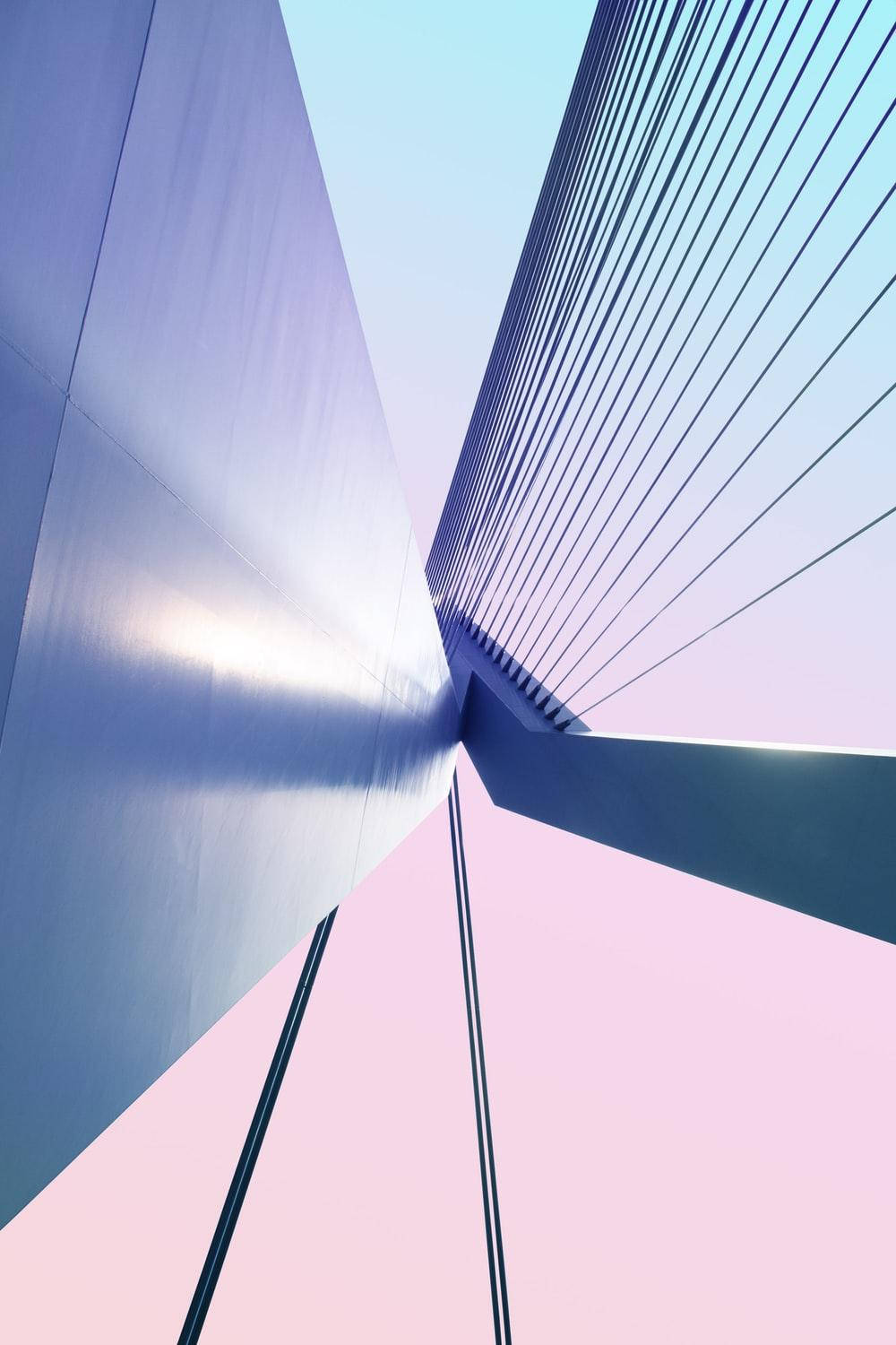 Architecture 桌布 壁紙 — 低角度拍攝的現代橋樑，帶有流線型鋼纜，背景是粉藍和粉紅色的柔和天空。