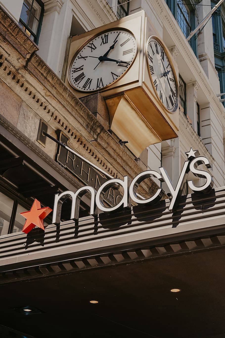macys 桌布 壁紙 — 低角度拍攝經典金色鐘樓，上方有Macy's百貨公司標誌及紅星。