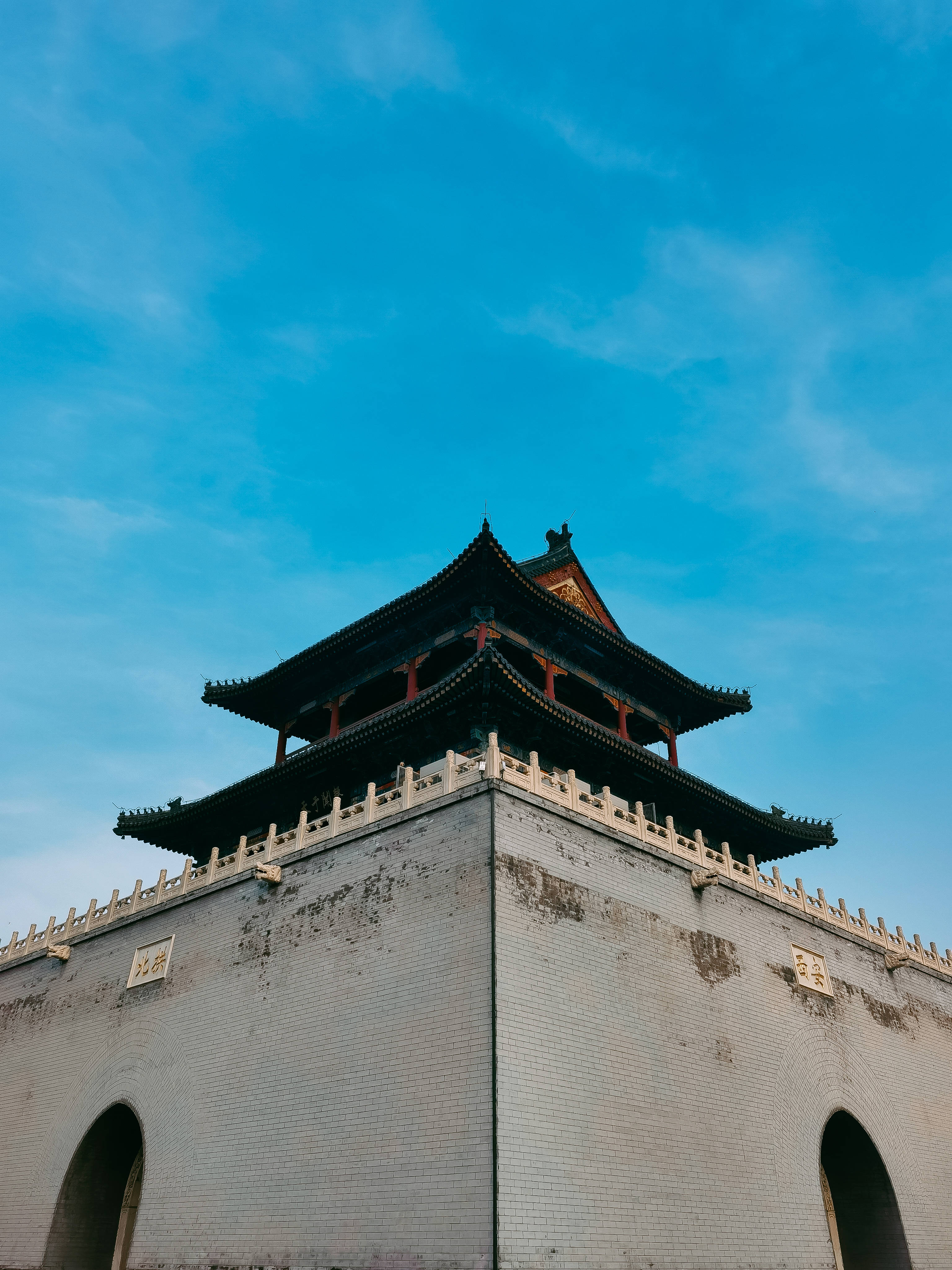Honor 桌布 壁紙 — 低角度觀看傳統中式門樓，彎曲的屋簷襯托著鮮豔的藍天。