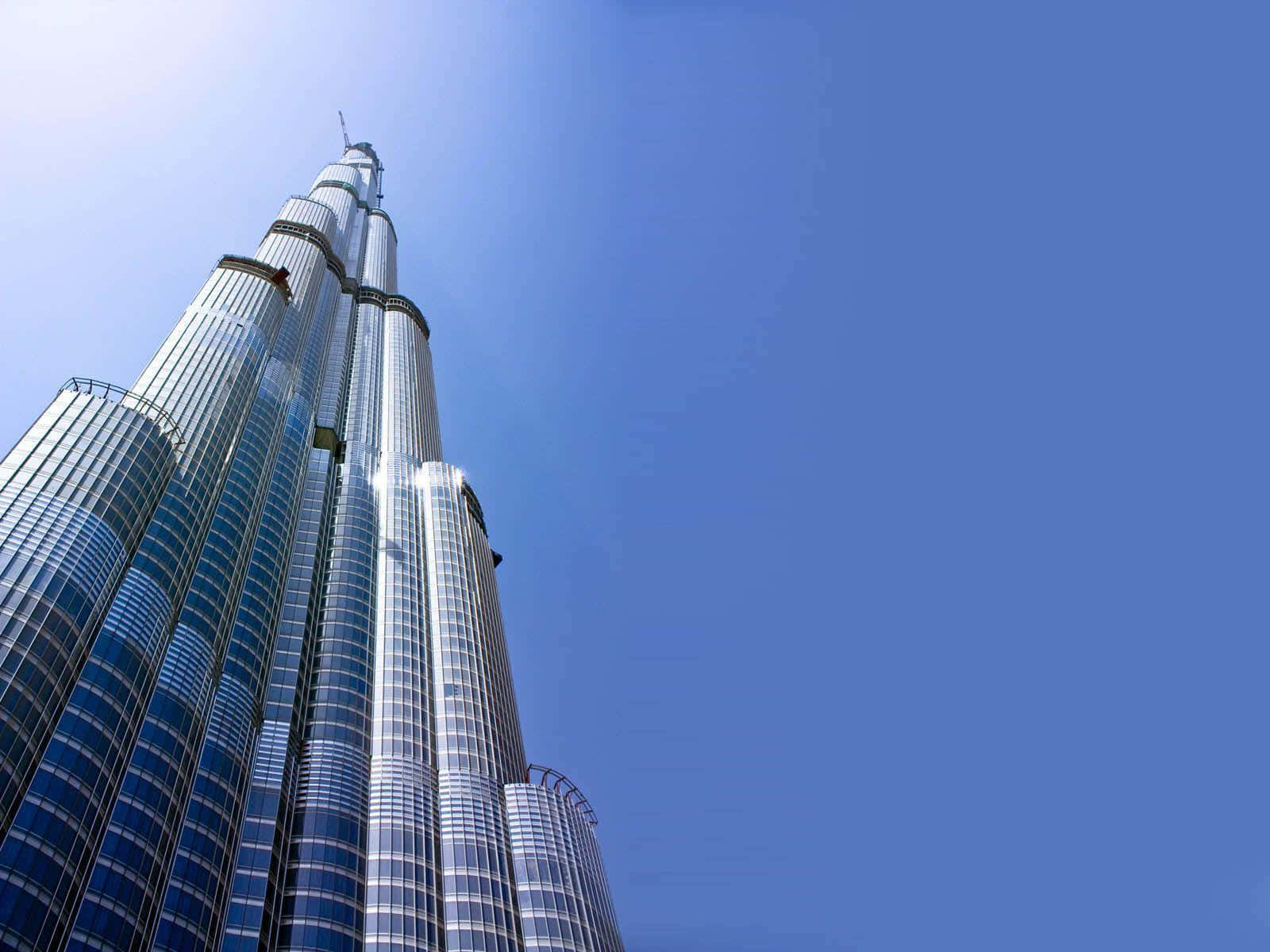 Burj Khalifa 桌布 壁紙 — 低角度觀看哈里發塔，其玻璃和鋼製尖頂刺穿清澈的藍天。