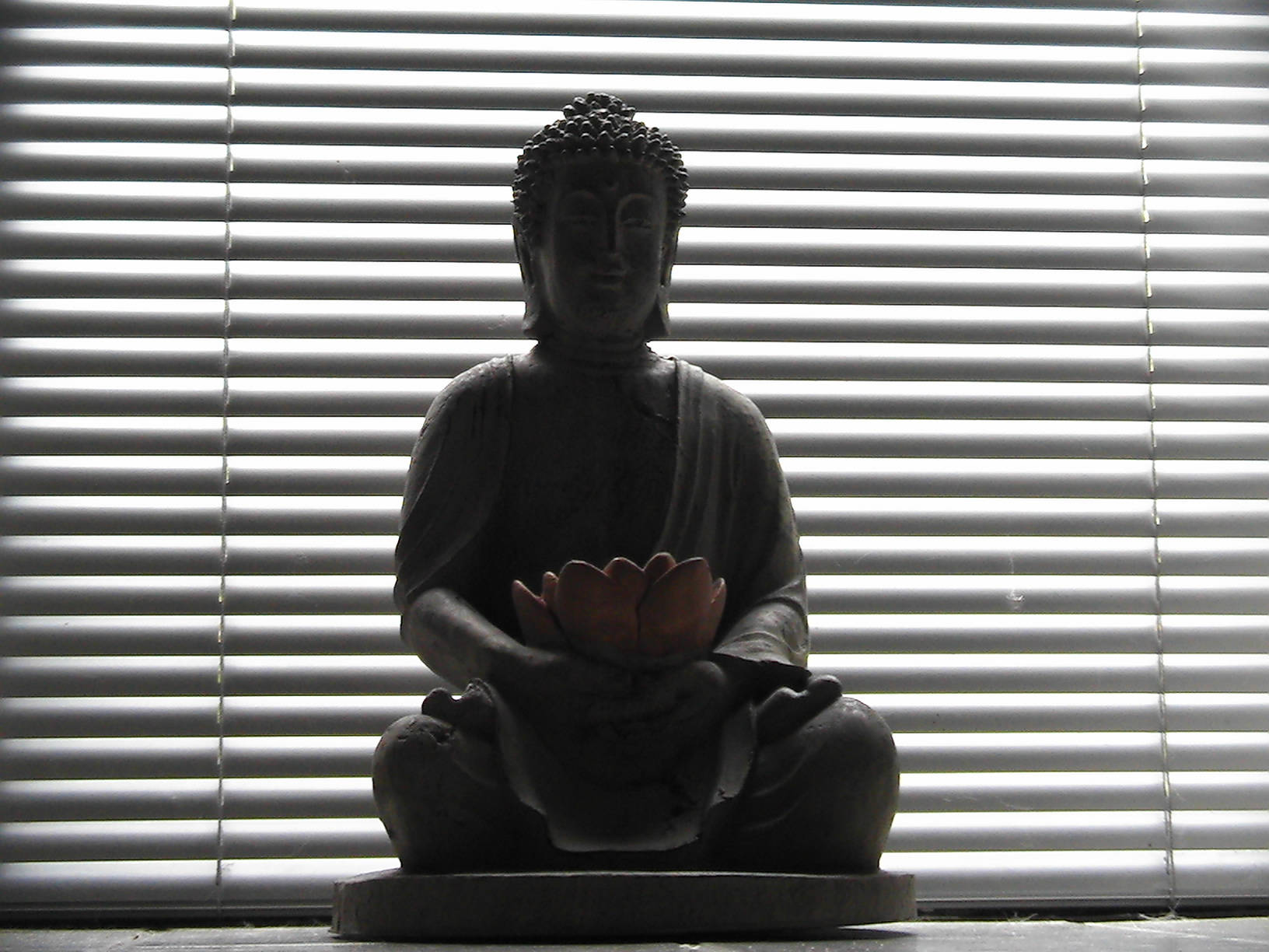 Silhouette 桌布 壁紙 — 佛像剪影手持蓮花，背景為明亮的水平百葉窗，投射出條紋陰影。