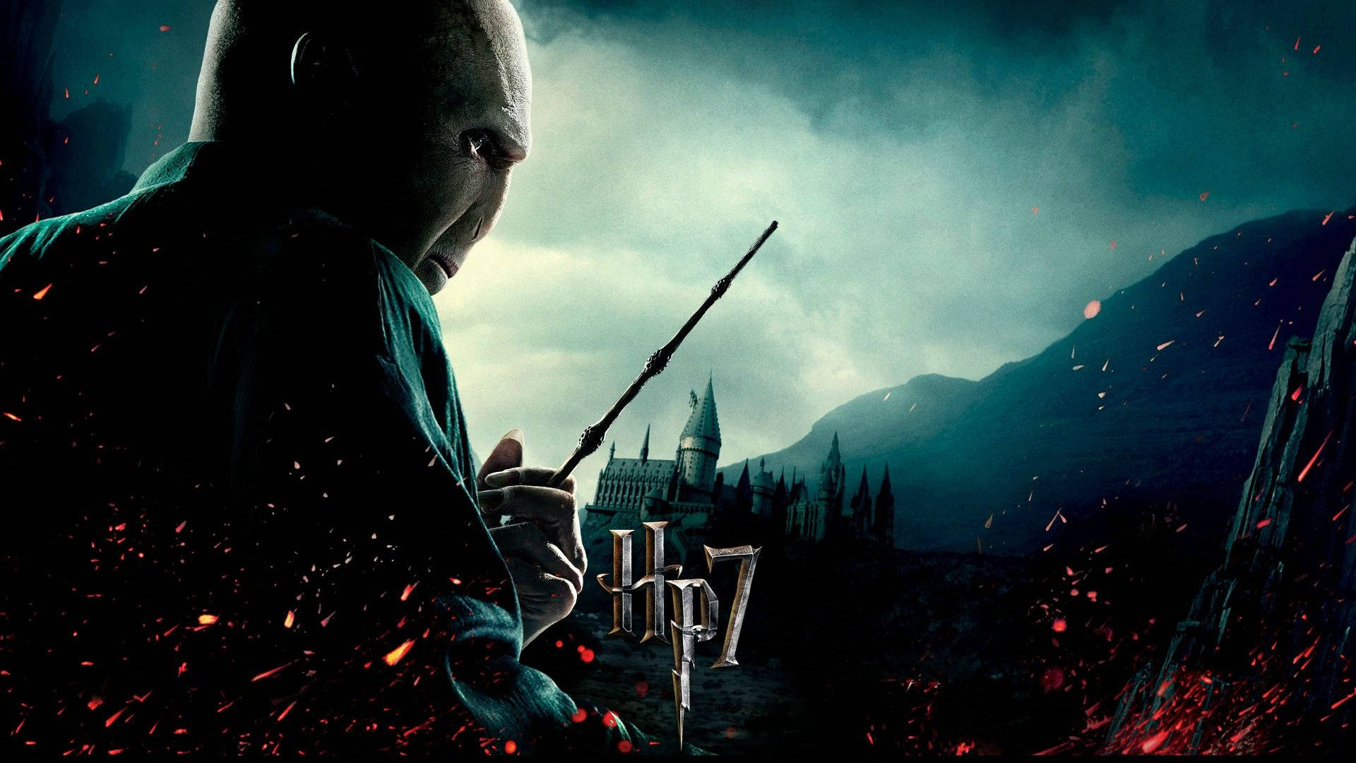 voldemort 桌布 壁紙 — 佛地魔在黑暗風暴場景中舉起魔杖，遠處有霍格華茲城堡，熾熱的火花在他周圍飛舞。