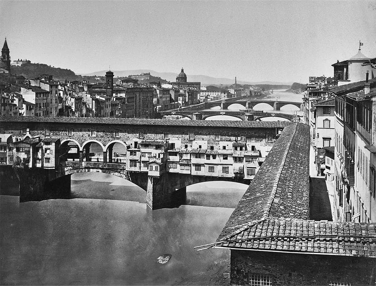 bridge 桌布 壁紙 — 佛羅倫斯舊橋橫跨阿諾河的歷史黑白景觀，密集的古老建築和遠山。