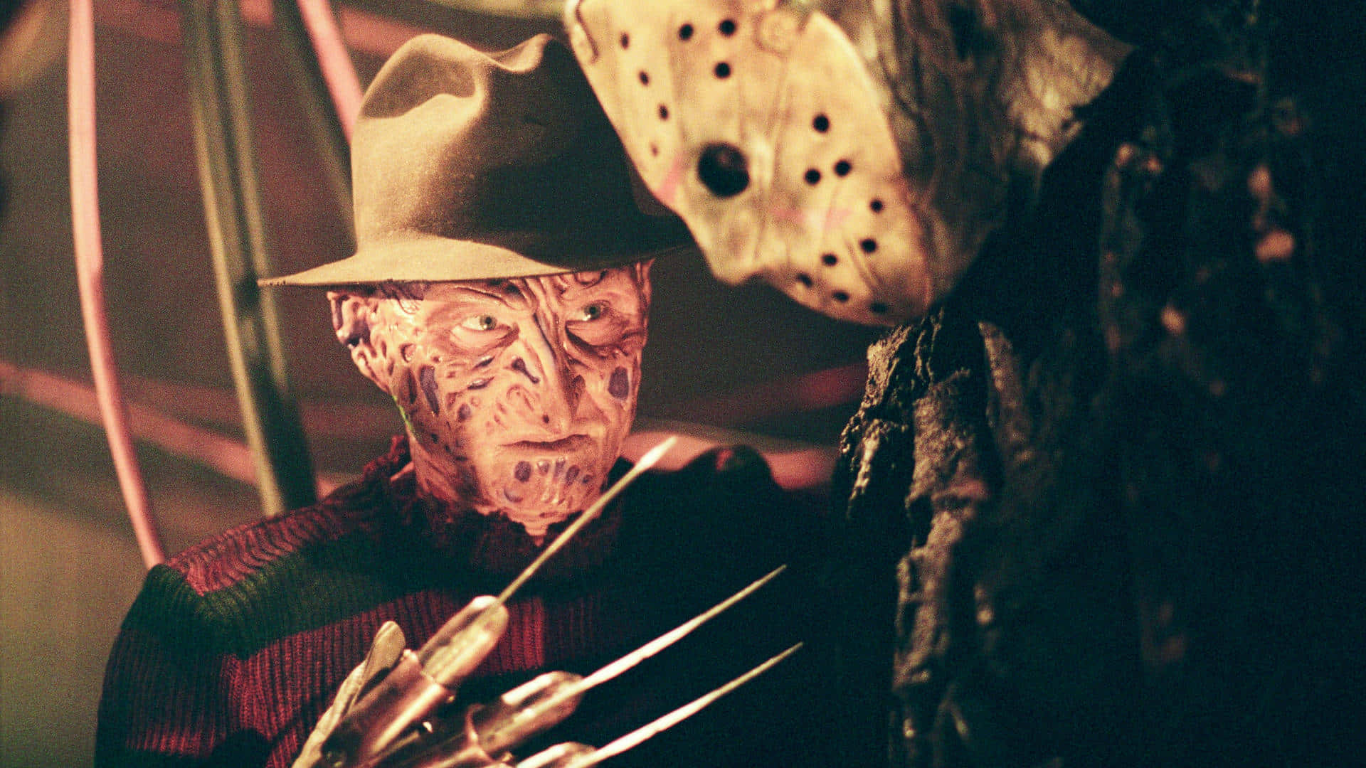 Freddy Krueger 桌布 壁紙 — 佛萊迪·克魯格戴著標誌性帽子和利刃手套，與戴著曲棍球面具的傑森·沃赫斯在緊張的恐怖場景中對峙。