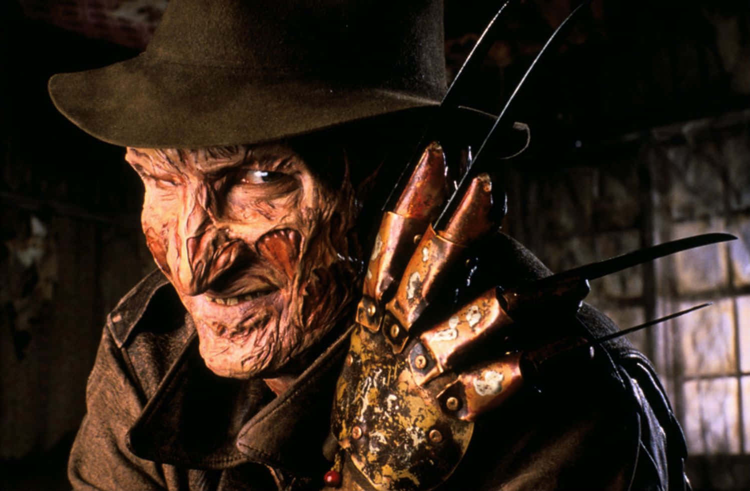 Freddy Krueger 桌布 壁紙 — 佛萊迪·克魯格的特寫，他燒傷的臉和刀片手套在昏暗的房間裡。