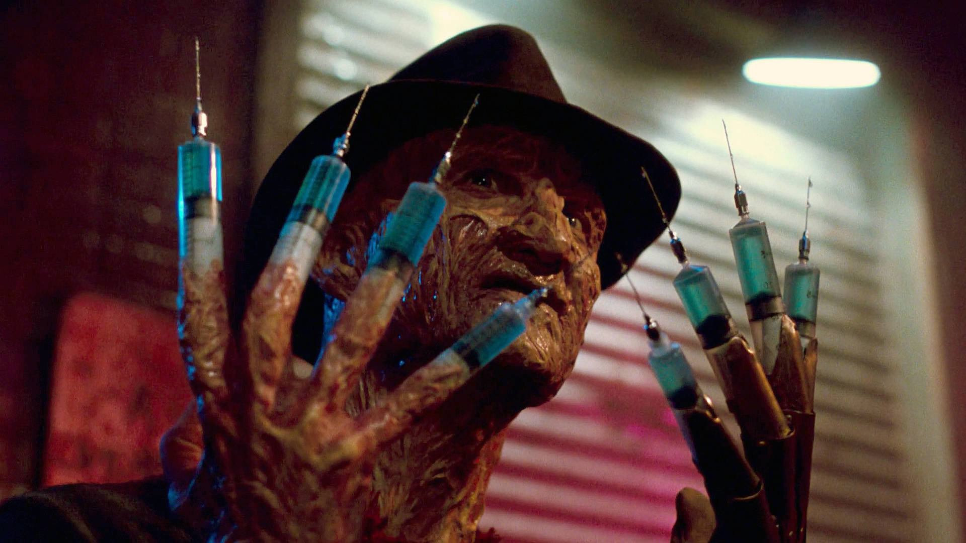 Freddy 桌布 壁紙 — 佛萊迪·克魯格的特寫，手指尖端如注射器，在昏暗的紅光下威脅性地逼近。
