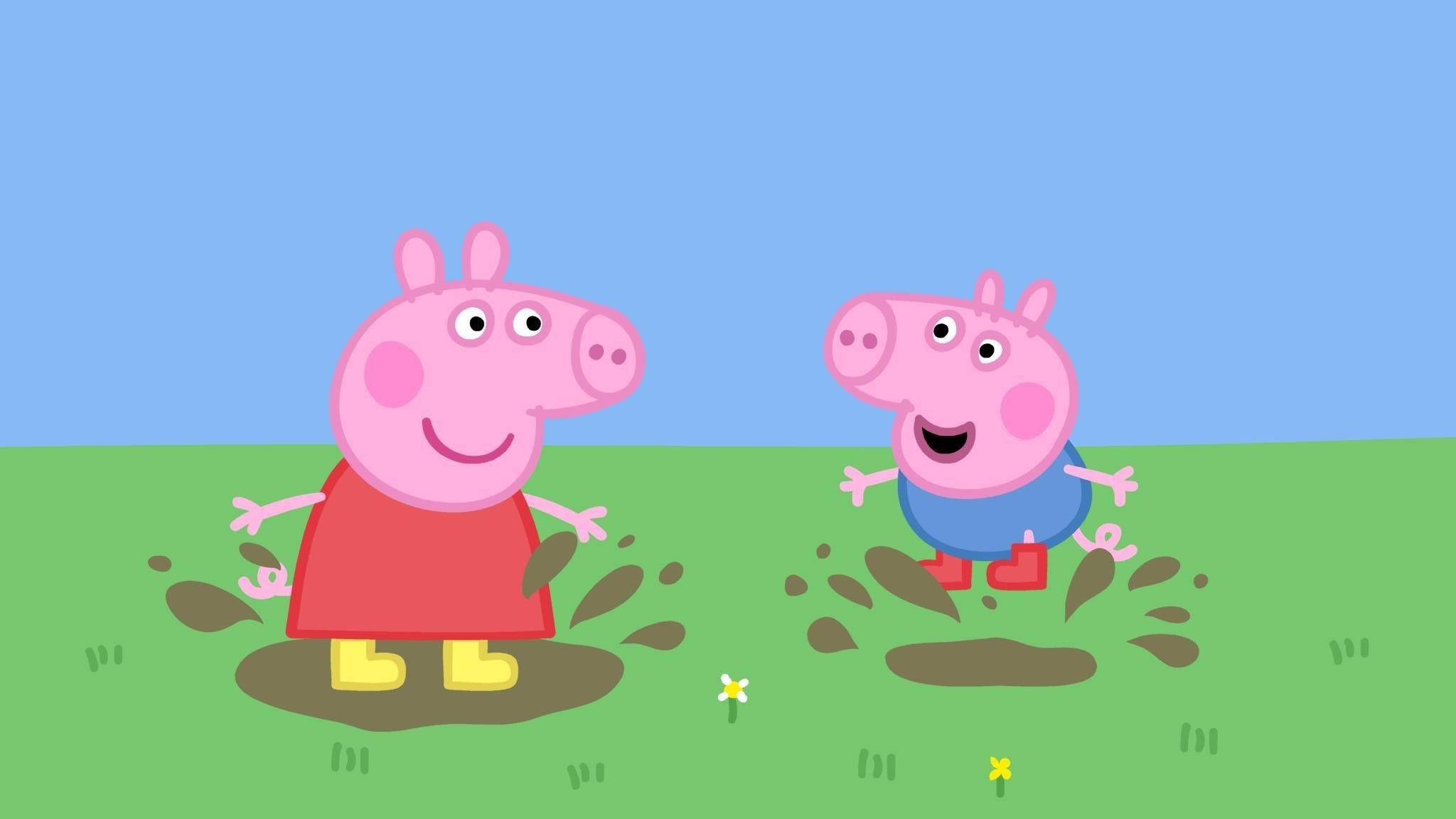 Peppa 桌布 壁紙 — 佩佩豬和她的弟弟喬治在晴朗的藍天下，於明亮的綠色田野上快樂地踩泥坑。