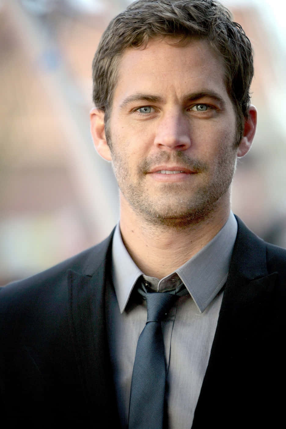Paul Walker 桌布 壁紙 — 保羅·沃克身穿深色西裝打領帶的特寫肖像，背景柔和模糊。