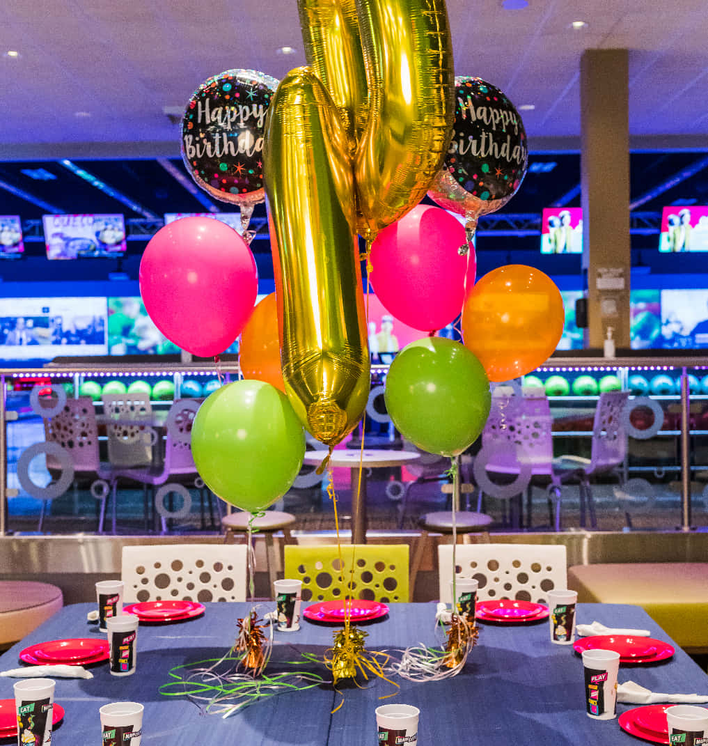 Balloons 桌布 壁紙 — 保齡球館內一個充滿節慶氣氛的生日餐桌，裝飾著色彩繽紛的氣球和派對用品。