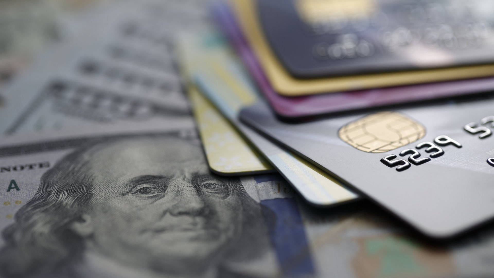 Credit Card 桌布 壁紙 — 信用卡散開在美元鈔票上的特寫，班傑明·富蘭克林的臉部清晰對焦。