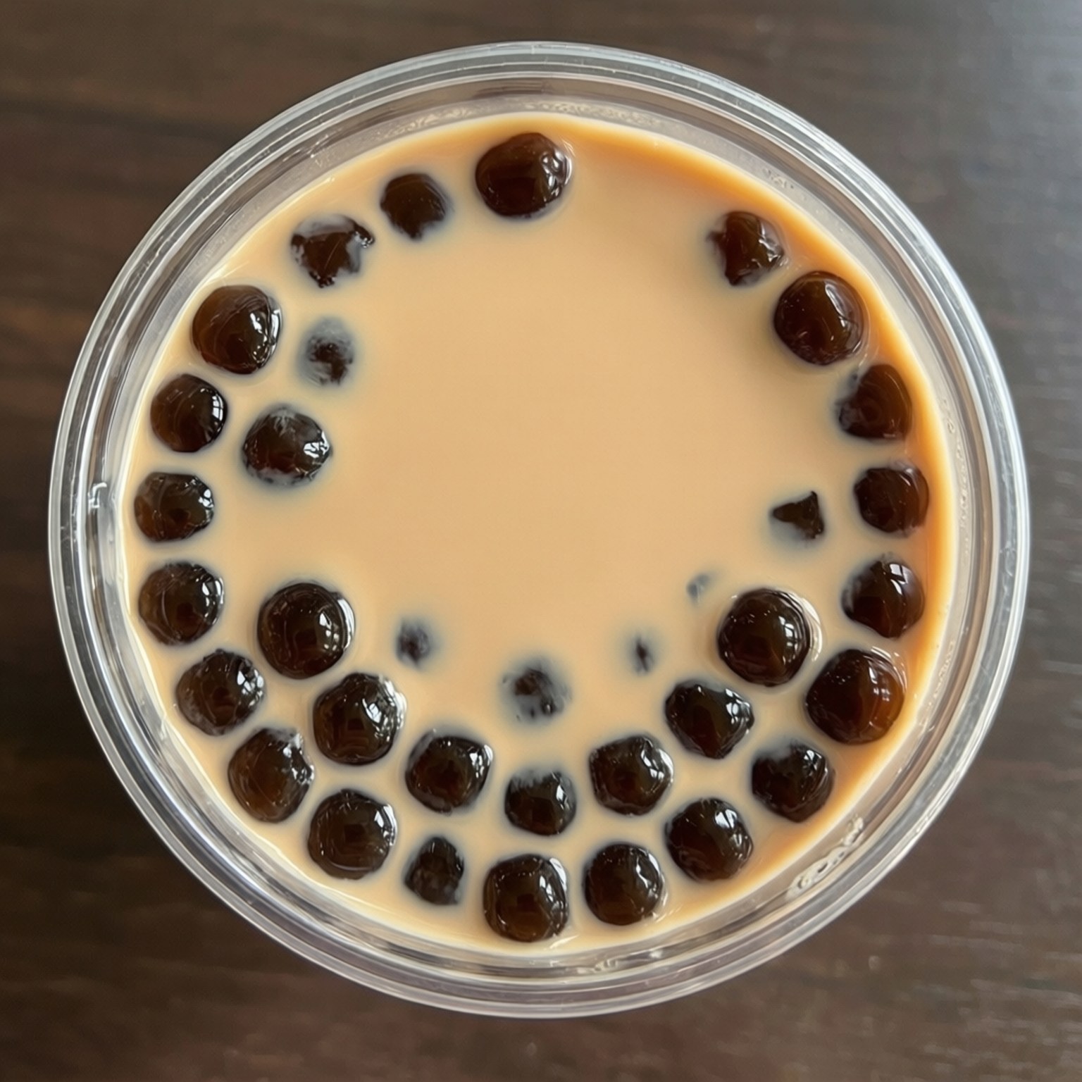從上方俯拍珍珠奶茶，珍珠排列成圖案。