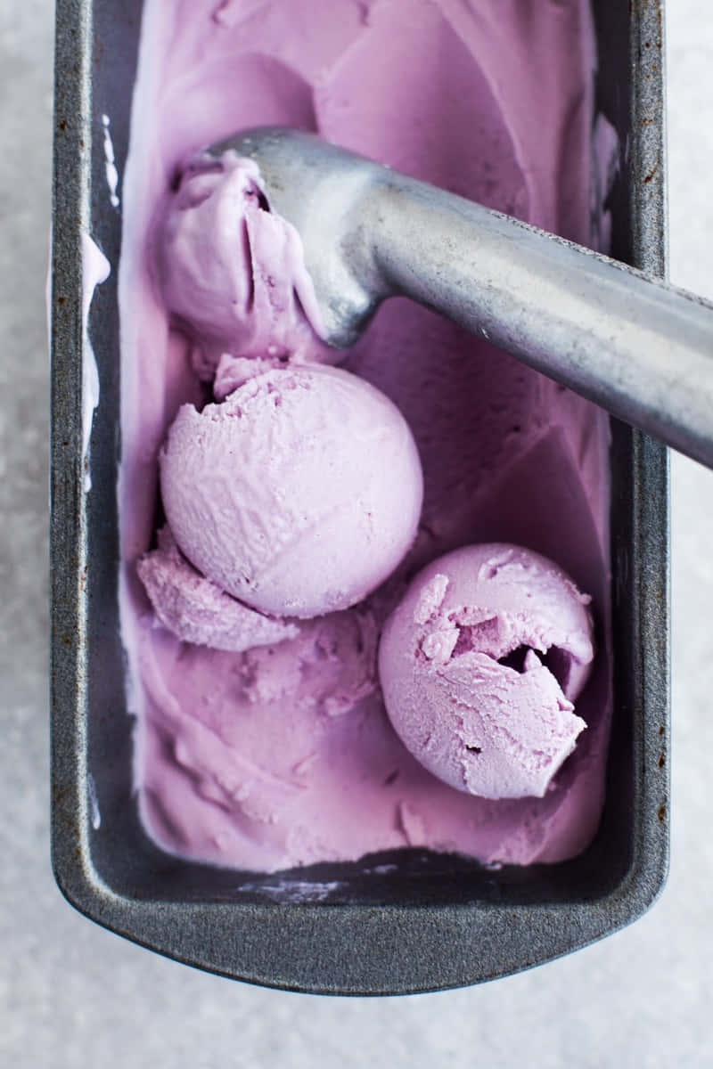 Ice Cream 桌布 壁紙 — 俯拍薰衣草冰淇淋球放在金屬麵包盤中，上面放著一個冰淇淋勺。