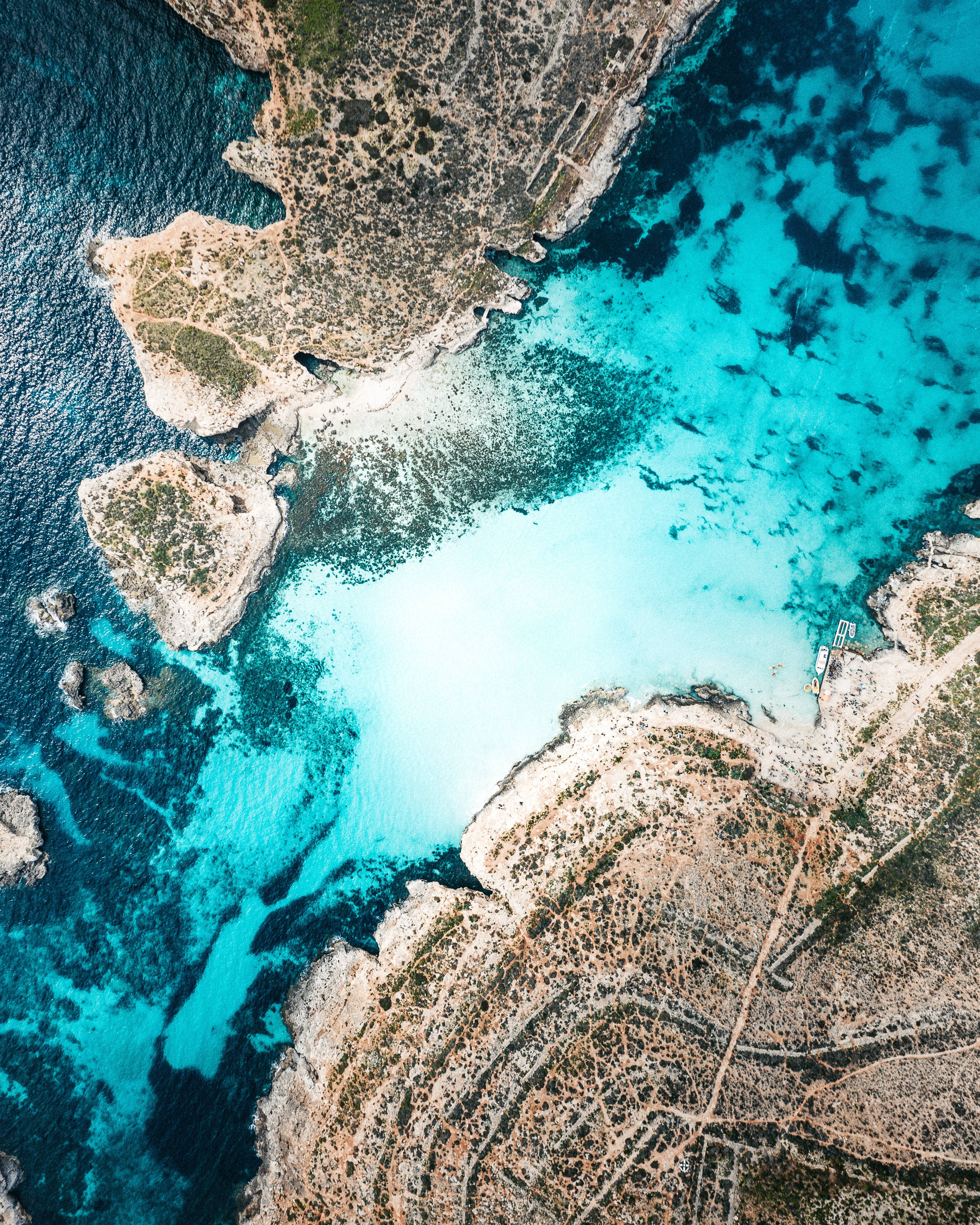 Malta 桌布 壁紙 — 俯瞰一個僻靜的海灣，碧綠的海水 nestled 在崎嶇的懸崖和沙灘之間。