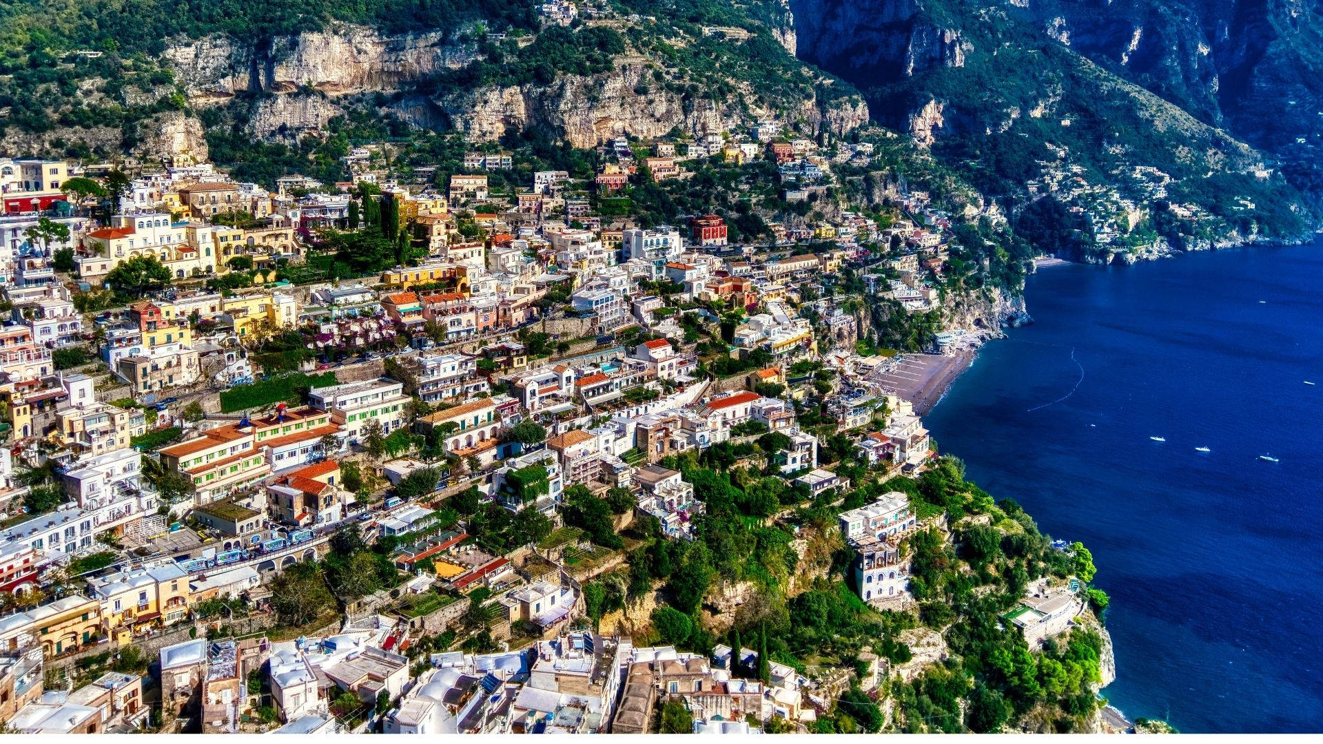 Amalfi Coast 桌布 壁紙 — 俯瞰一個充滿活力的沿海小鎮，緊貼陡峭懸崖，俯瞰深藍色海洋。