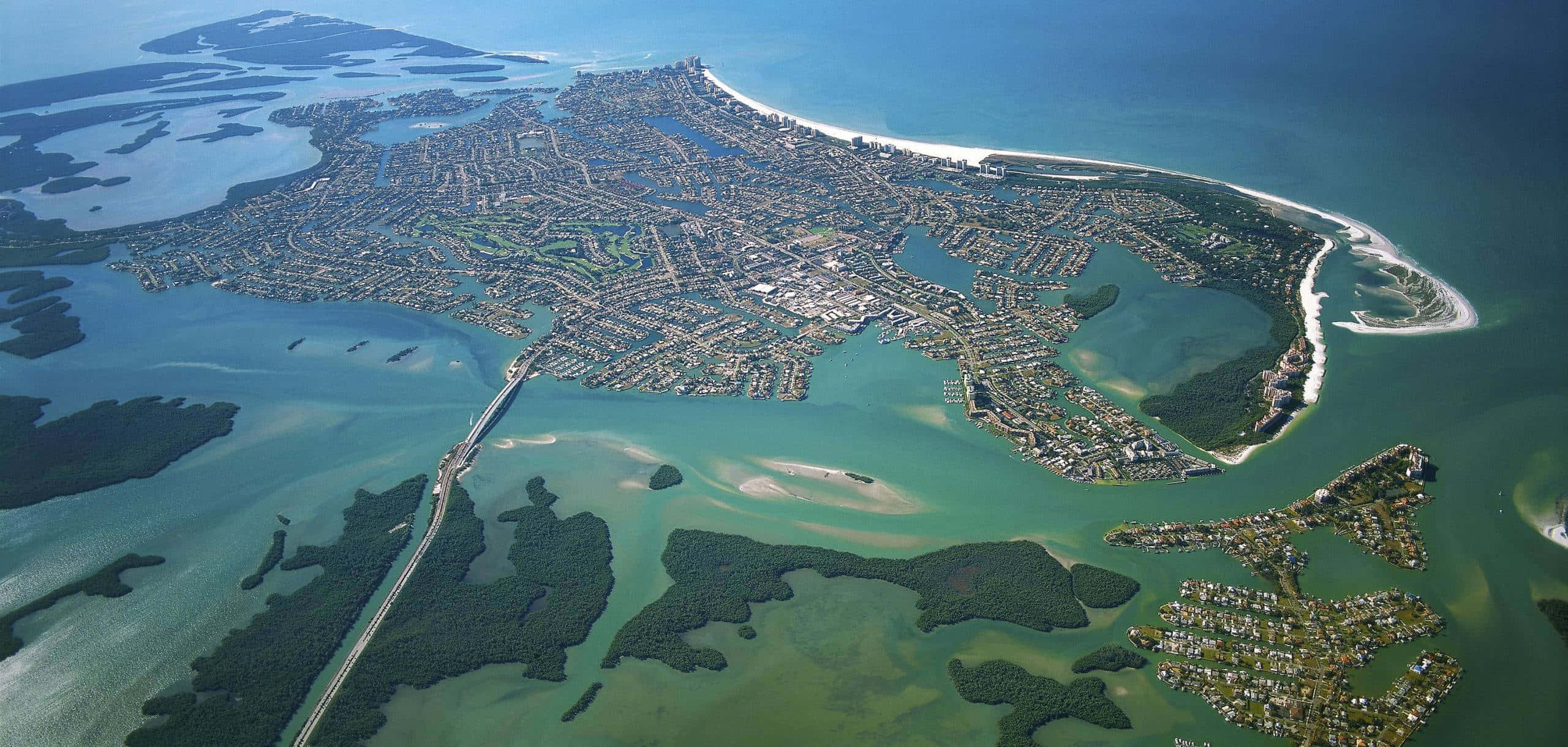 Marco Island 桌布 壁紙 — 俯瞰一個坐落在屏障島上的沿海小鎮，四周環繞著碧綠的海水和茂密的綠植。