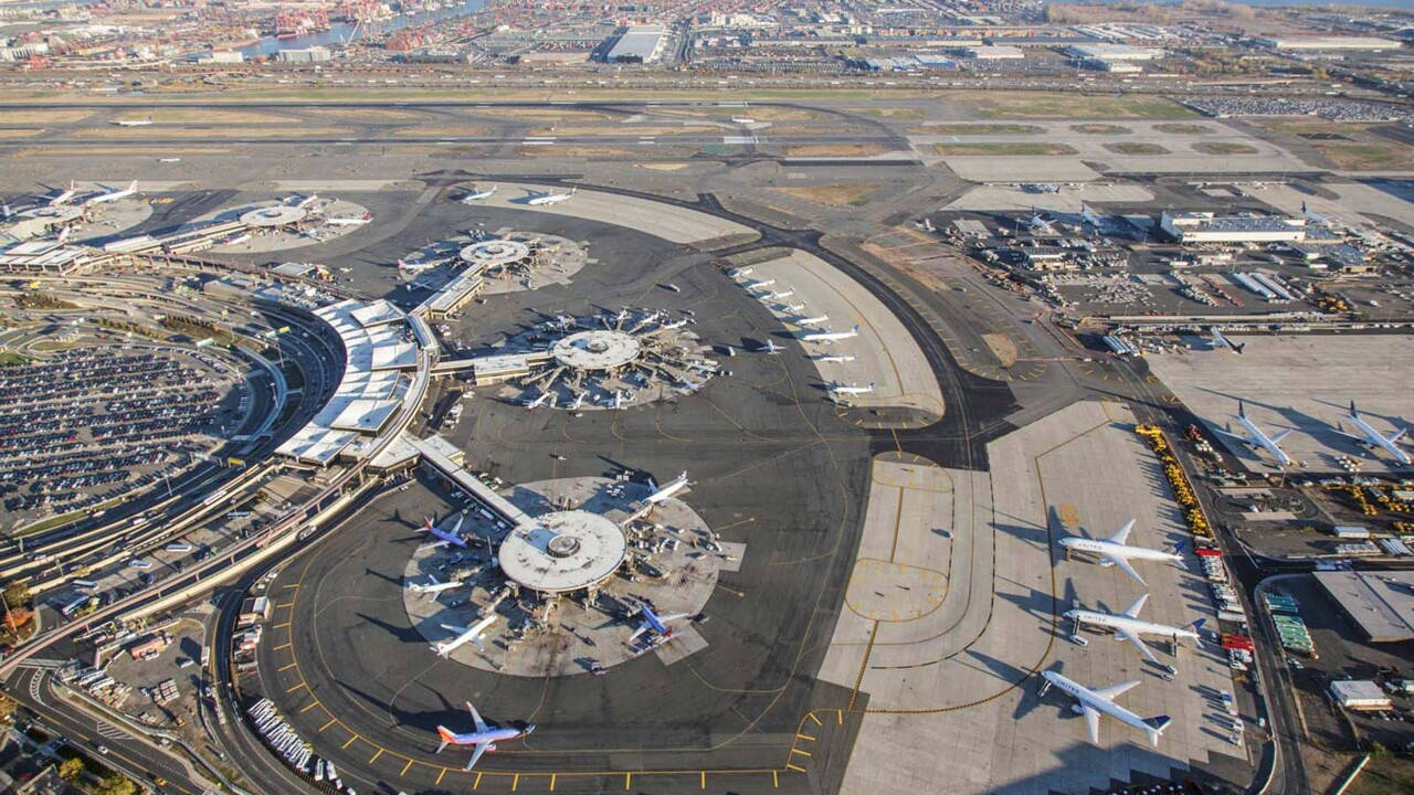 Airport 桌布 壁紙 — 俯瞰一個廣闊的機場航廈，設有同心圓形走廊，周圍是停泊的飛機和滑行道。