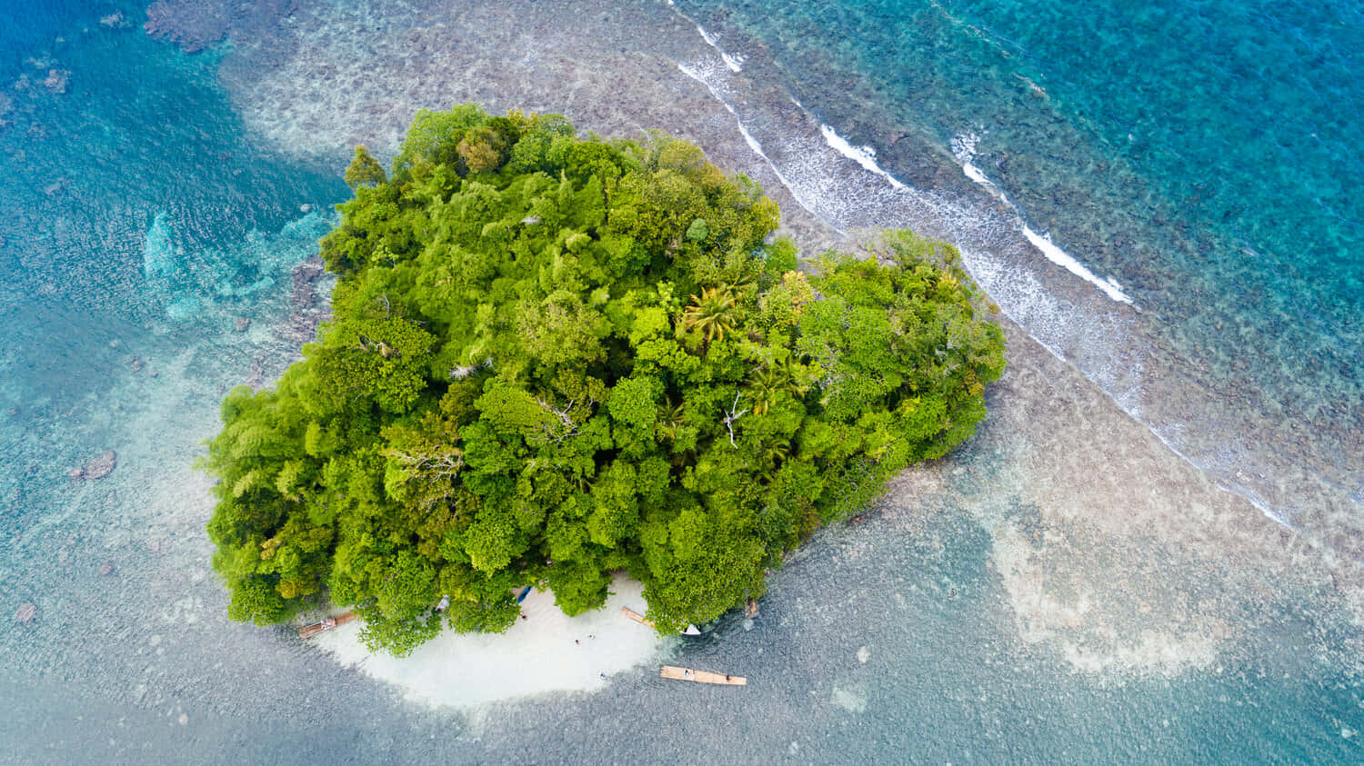 Jamaican Island 桌布 壁紙 — 俯瞰一個鬱鬱蔥蔥的熱帶島嶼，擁有白色沙灘，被碧綠的海洋和珊瑚礁環繞。