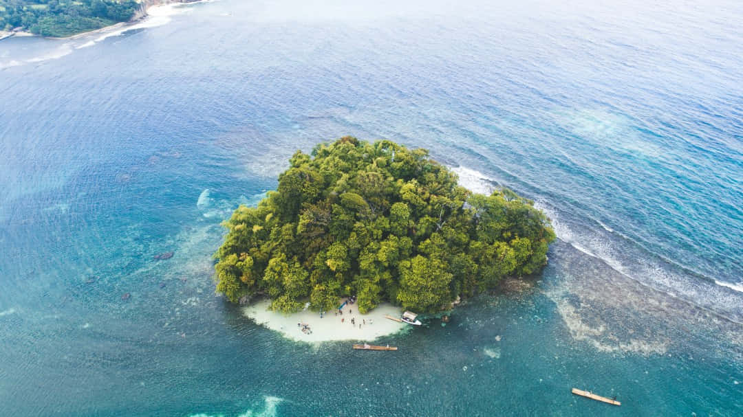 Jamaican Island 桌布 壁紙 — 俯瞰一個鬱鬱蔥蔥的熱帶島嶼，擁有白色沙灘，被碧綠的海浪環繞。