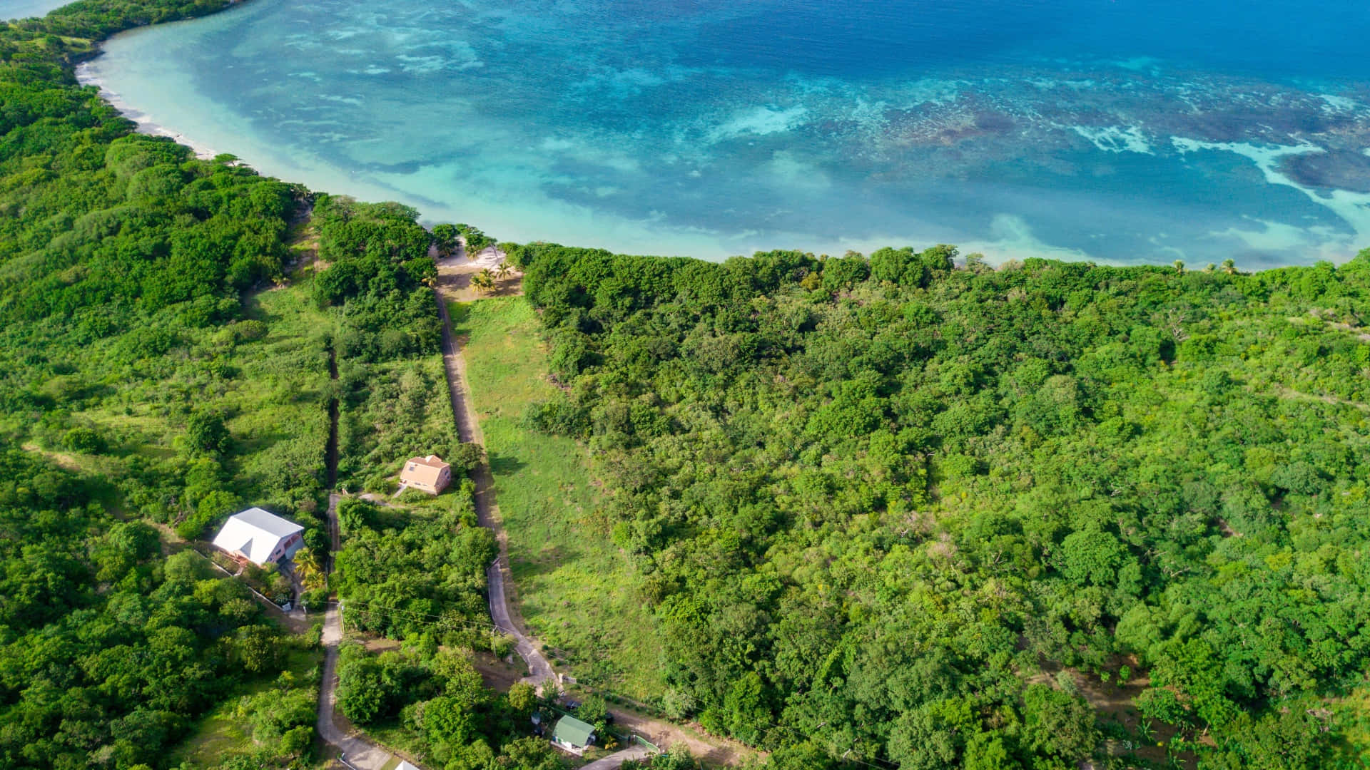 Fiji Beach 桌布 壁紙 — 俯瞰一個鬱鬱蔥蔥的熱帶島嶼，蜿蜒的道路通往純淨的綠松石色海岸線。