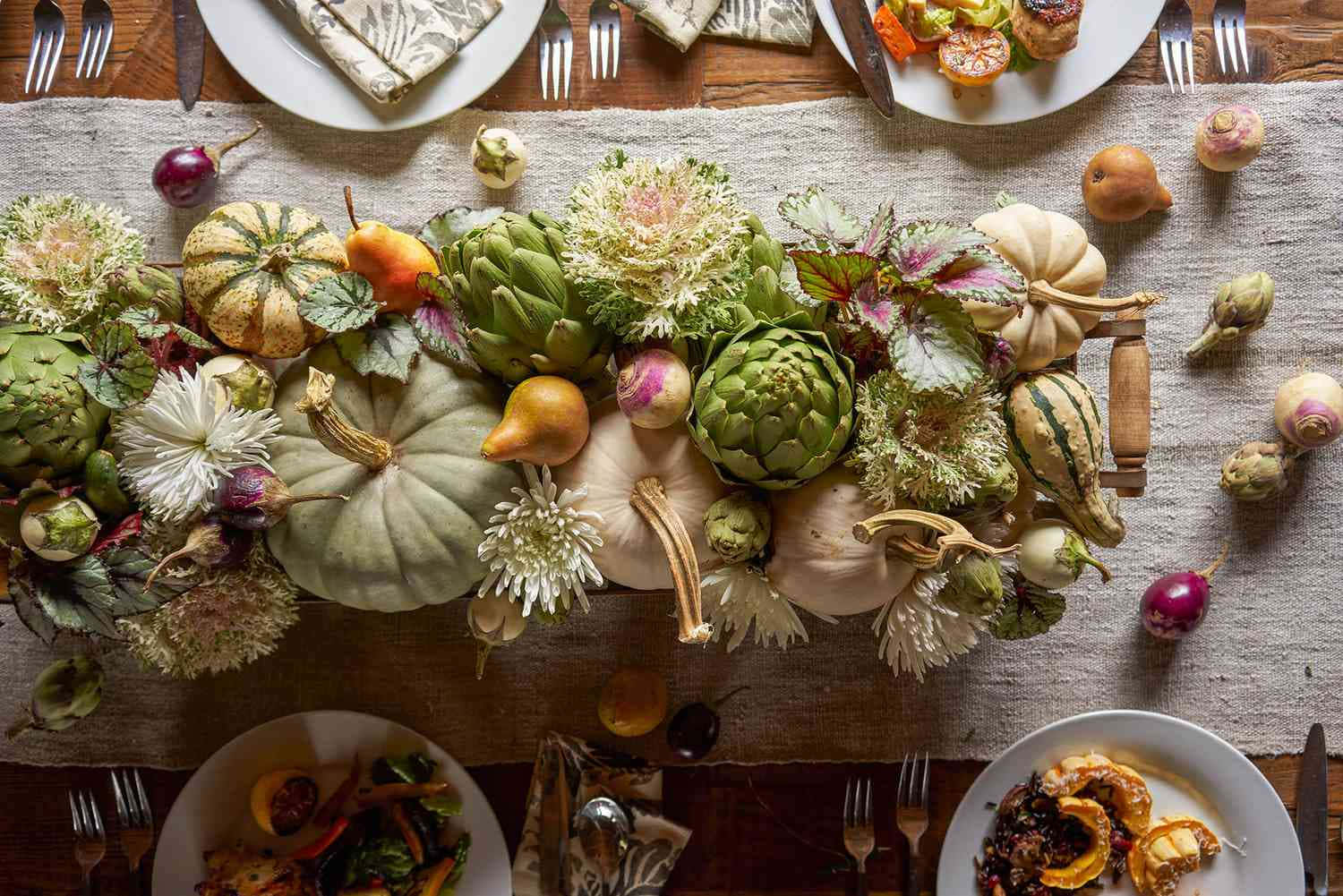 Fall Thanksgiving 桌布 壁紙 — 俯瞰一張鄉村風格的秋季餐桌，上面鋪著亞麻桌旗，擺放著南瓜、朝鮮薊、鮮花和擺盤好的食物。
