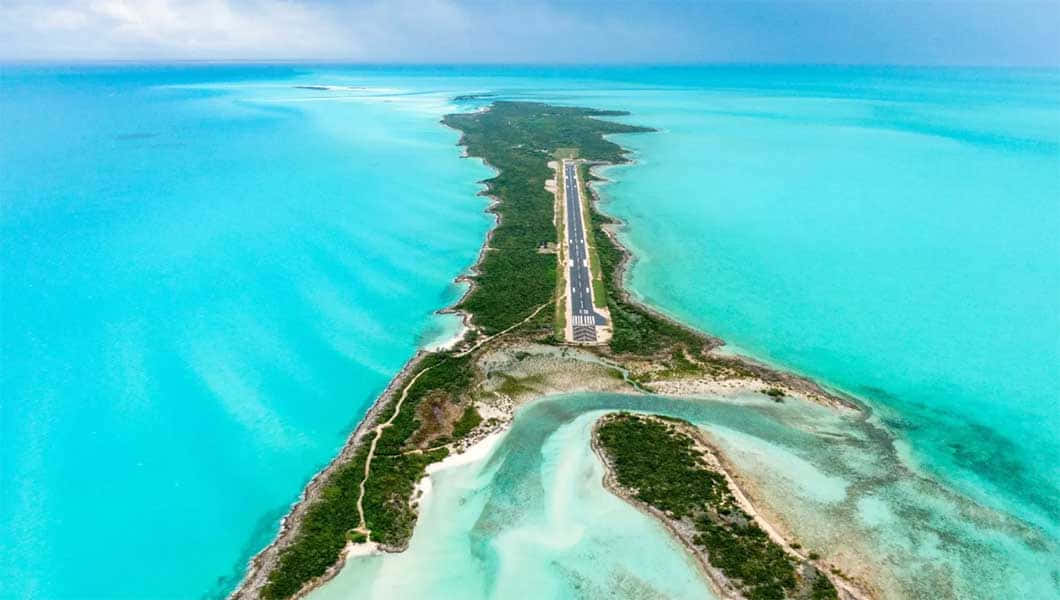 Bahamas Island 桌布 壁紙 — 俯瞰一條狹長熱帶島嶼上建造的長跑道，周圍環繞著充滿活力的碧綠海水。