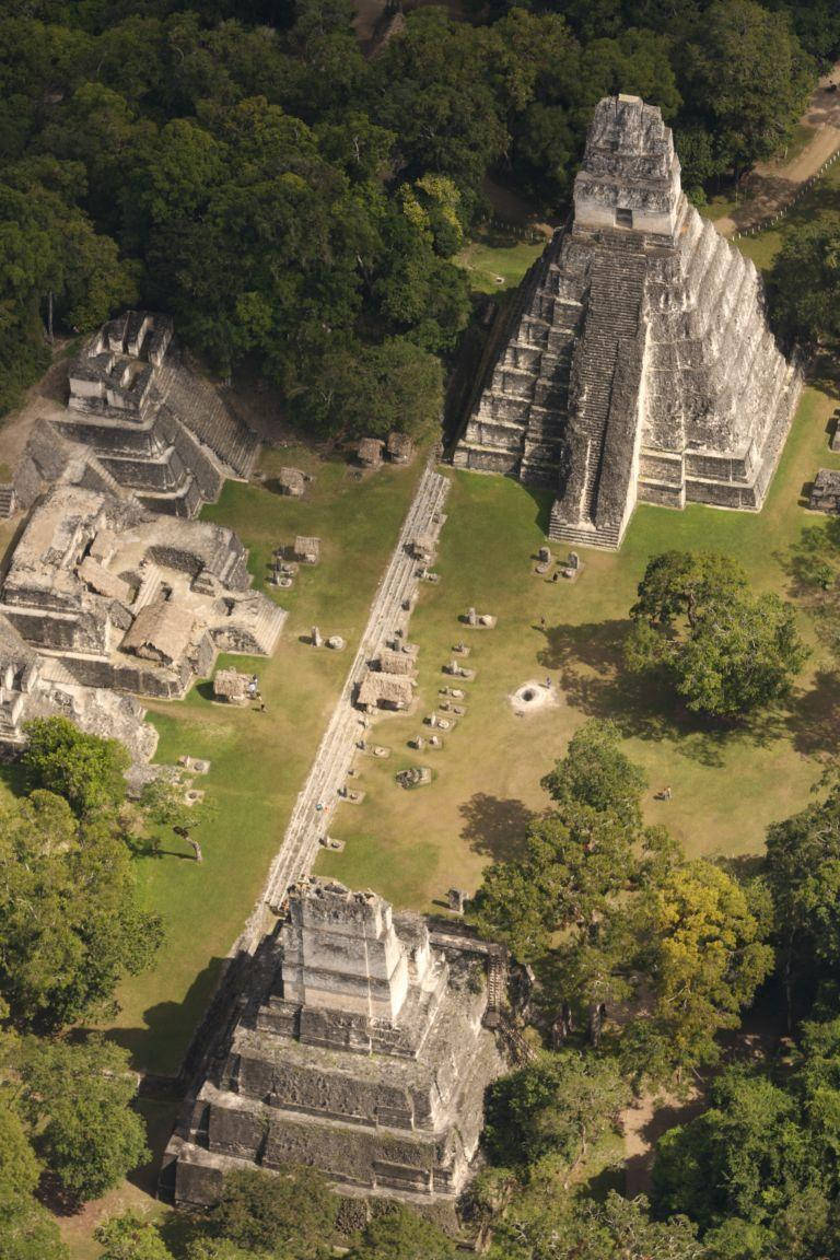 Guatemala 桌布 壁紙 — 俯瞰古老瑪雅金字塔和遺跡，隱藏在茂密翠綠的叢林樹冠中。