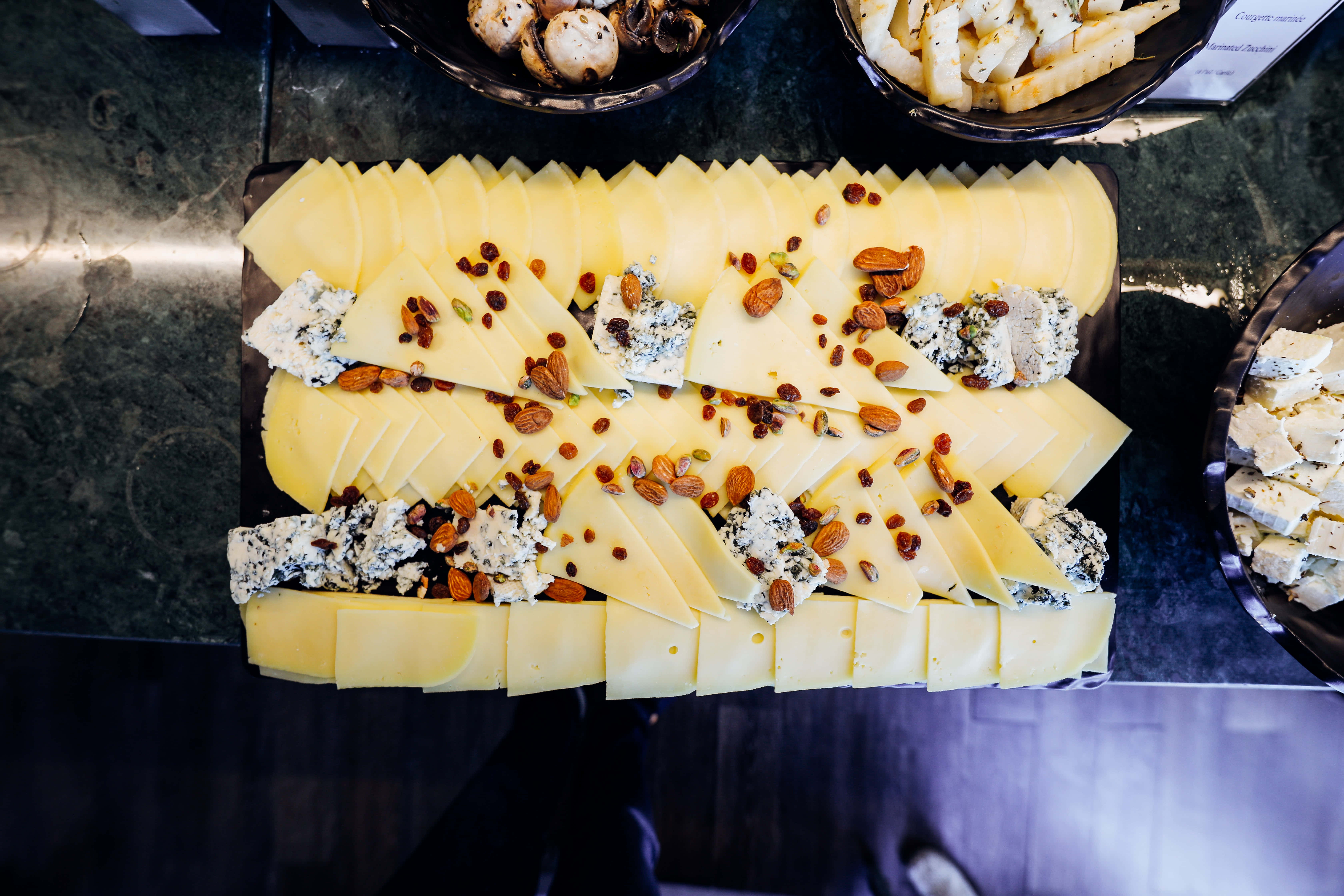 Cheese 桌布 壁紙 — 俯瞰圖：深色大理石檯面上擺放著切片黃芝士、藍芝士塊、杏仁和葡萄乾的美食芝士板。