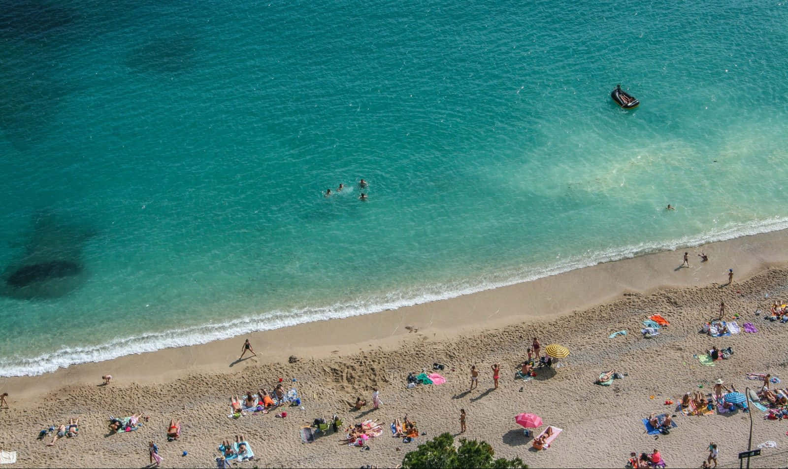 French Beach 桌布 壁紙 — 俯瞰擠滿人群的海灘，碧綠海水與金色沙灘上享受日光浴的人們。