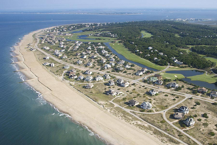 North Carolina 桌布 壁紙 — 俯瞰沿海社區，擁有海濱住宅、蜿蜒道路和與海洋接壤的鬱鬱蔥蔥的高爾夫球場。