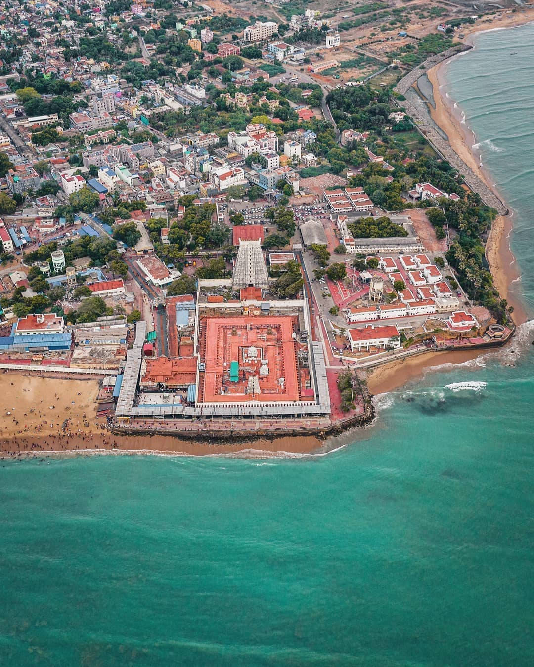風景 桌布 壁紙 — 俯瞰海岸寺廟建築群，紅色屋頂點綴在碧綠海水與繁華城鎮之間。