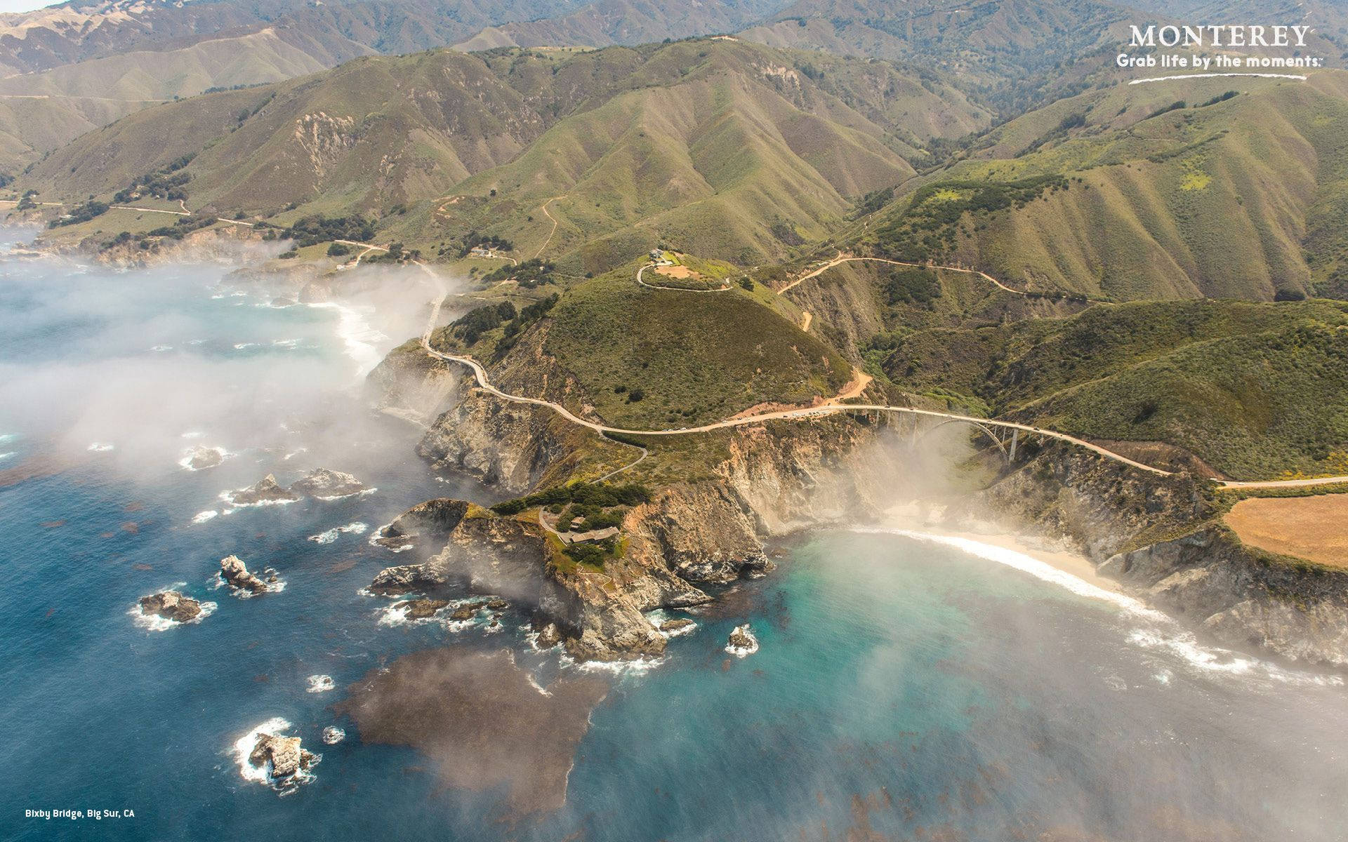 Monterey 桌布 壁紙 — 俯瞰蜿蜒的海岸公路緊貼懸崖，碧綠的海洋和霧氣翻滾過岩石海岸。