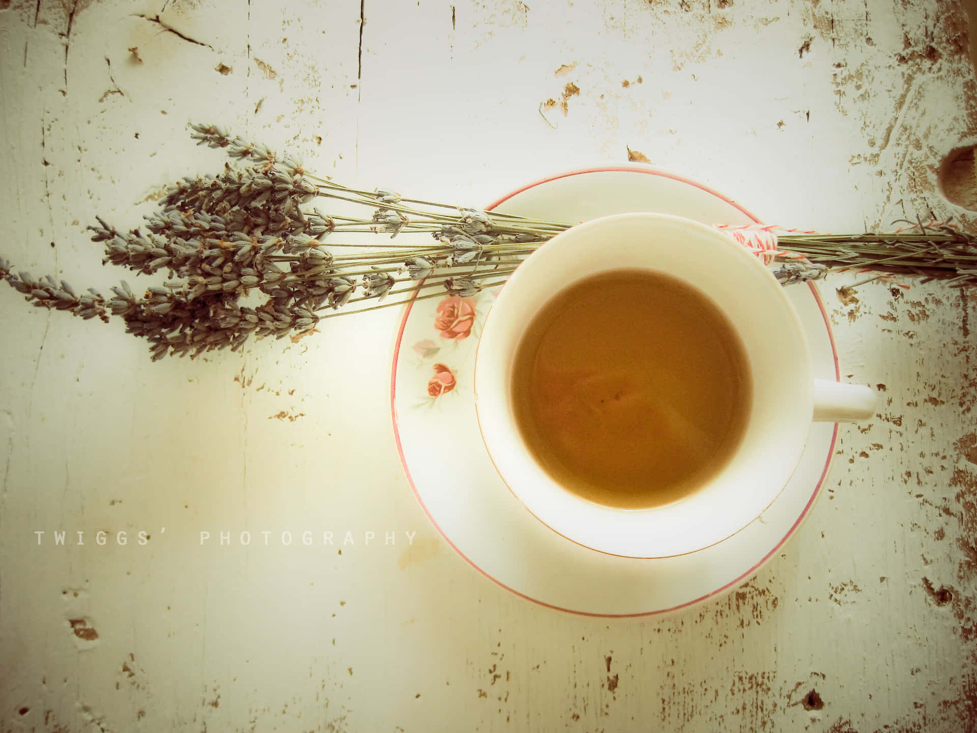 咖啡動圖 桌布 壁紙 — 俯視一個白色茶杯，盛滿琥珀色茶，旁邊放有乾燥薰衣草，置於經風化的白色木質表面上。