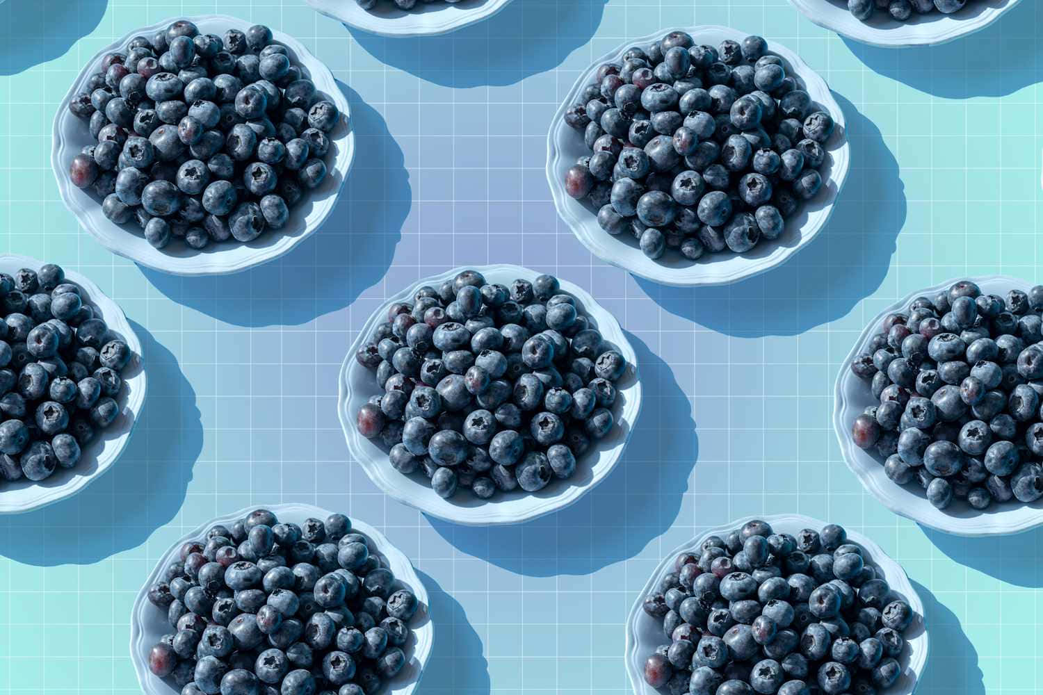 Blueberry 桌布 壁紙 — 俯視白色碗裝滿飽滿藍莓，在淺藍色網格背景上投下清晰陰影。