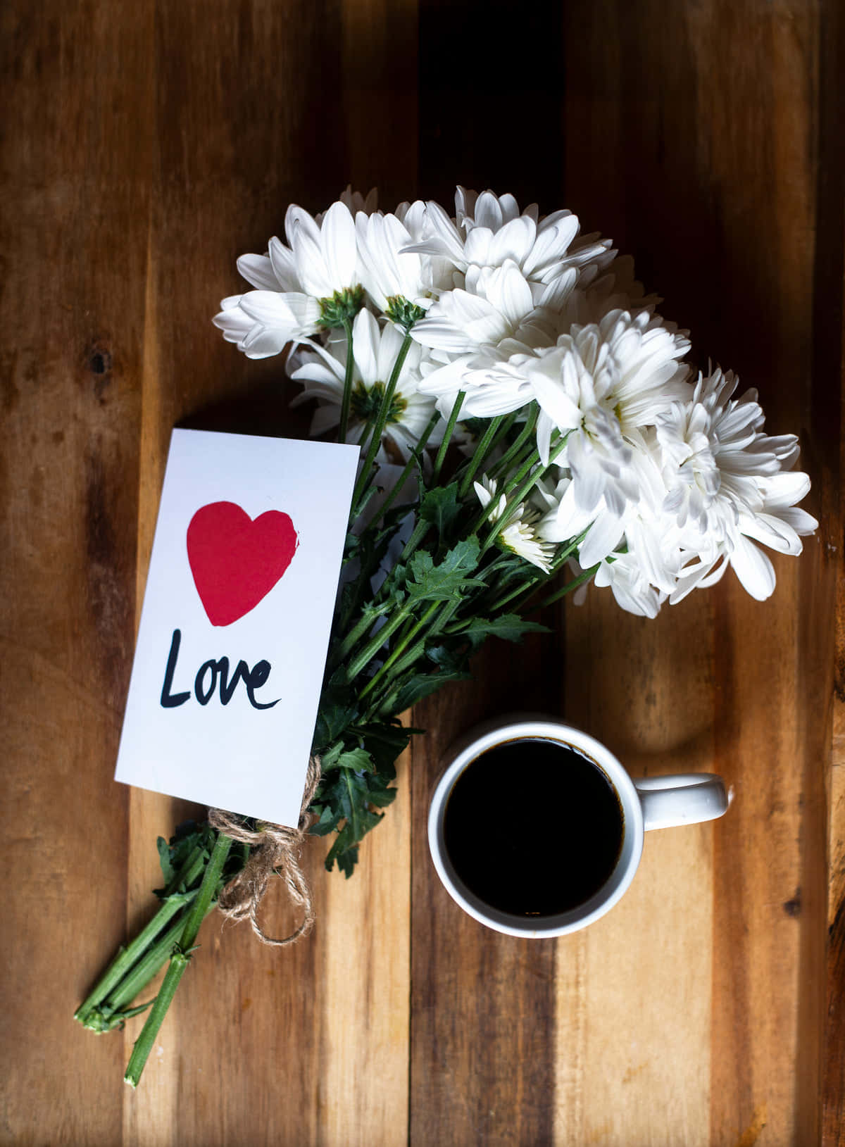 Romantic Love 桌布 壁紙 — 俯視角度拍攝，白色雛菊、紅色心形便條和黑色咖啡杯擺放在溫暖的木質表面上。