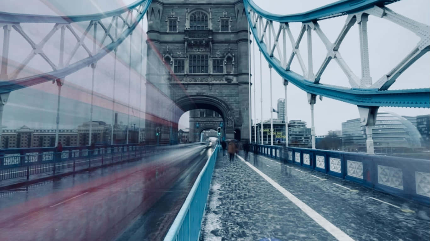 bridge 桌布 壁紙 — 倫敦塔橋上的一個雨天，一輛模糊的紅色巴士疾馳而過，一個孤獨的行人在潮濕的走道上行走。