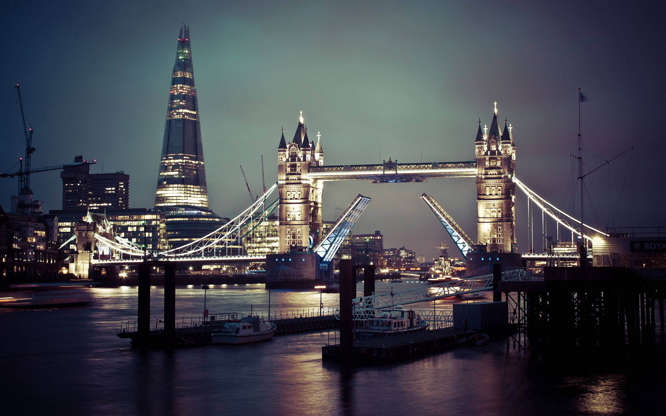 England 桌布 壁紙 — 倫敦塔橋在夜間亮燈，吊橋升起，碎片大廈在泰晤士河上閃耀。