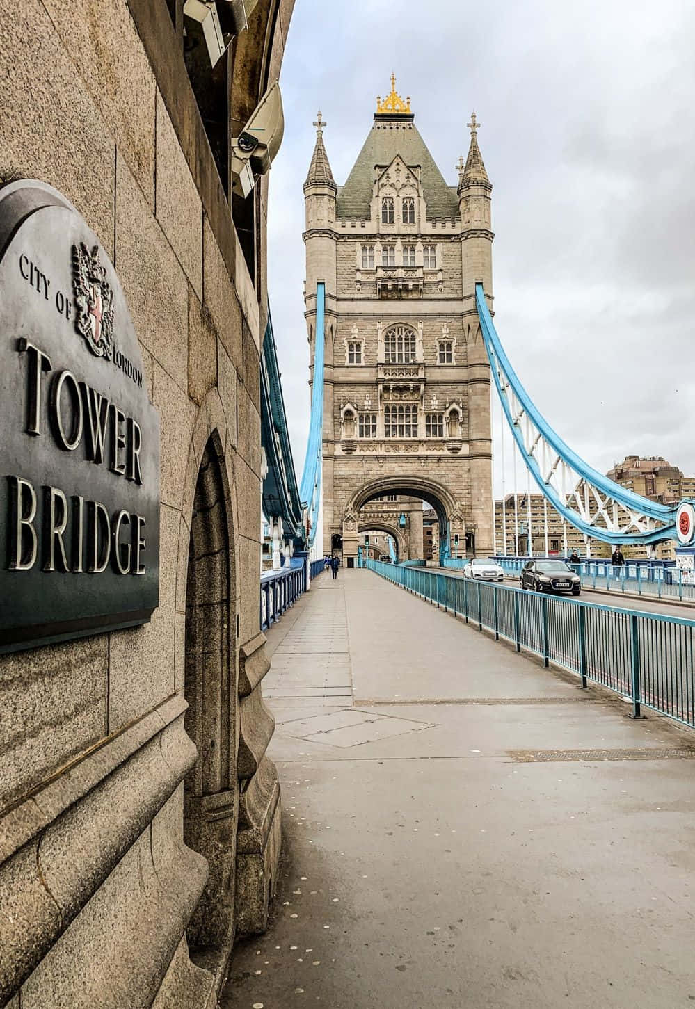 bridge 桌布 壁紙 — 倫敦塔橋的低角度視圖，其標誌性的石塔和藍色懸索在陰天之下。