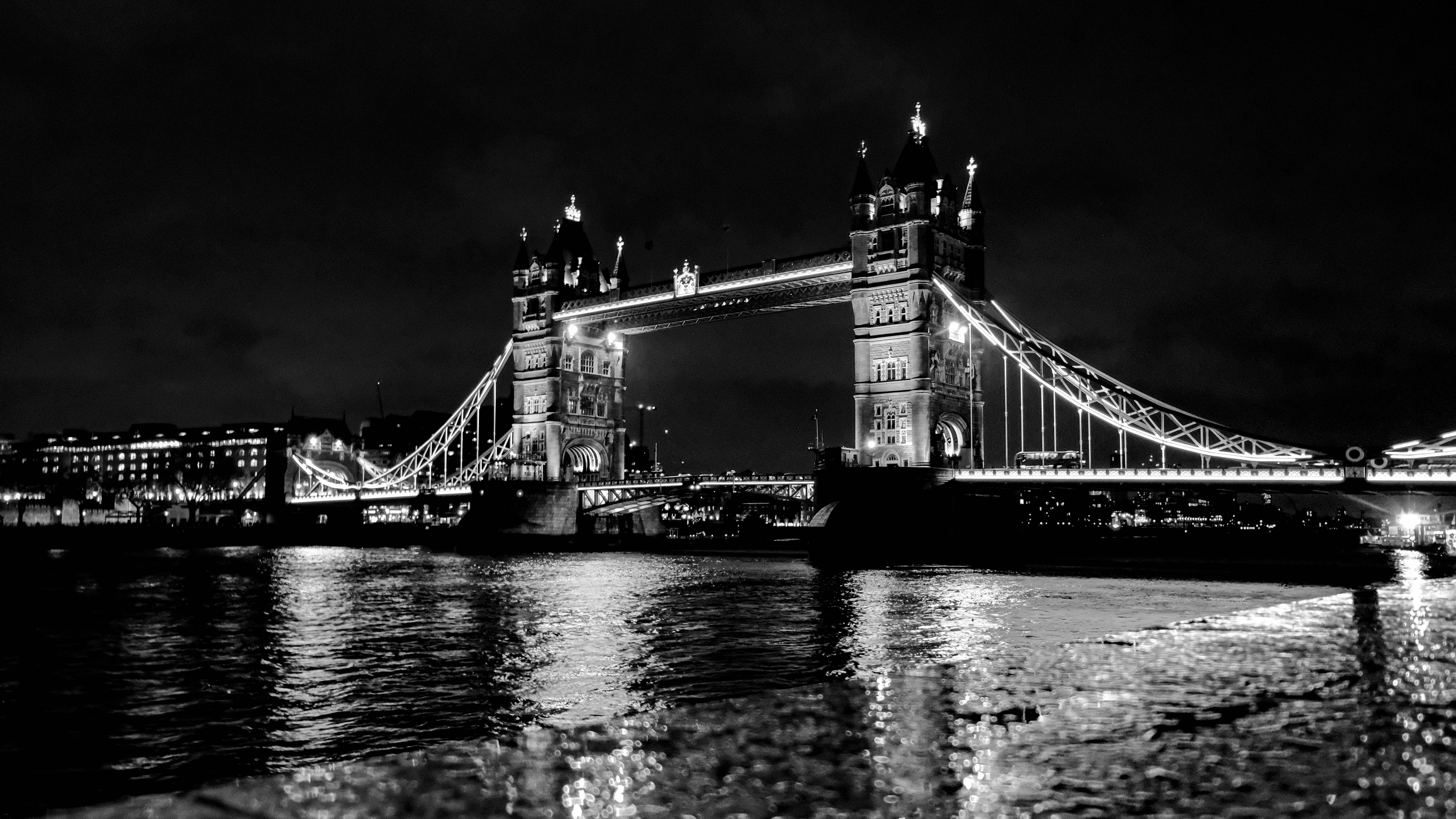 bridge 桌布 壁紙 — 倫敦塔橋的醒目黑白夜景，燈光倒映在下面的河面上。