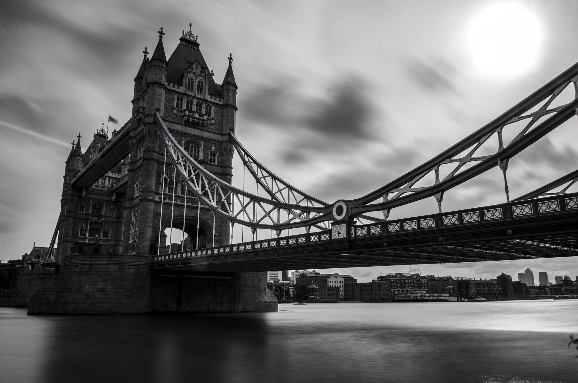 bridge 桌布 壁紙 — 倫敦塔橋的黑白長時間曝光，戲劇性的天空下帶有條紋雲和光滑的河水。